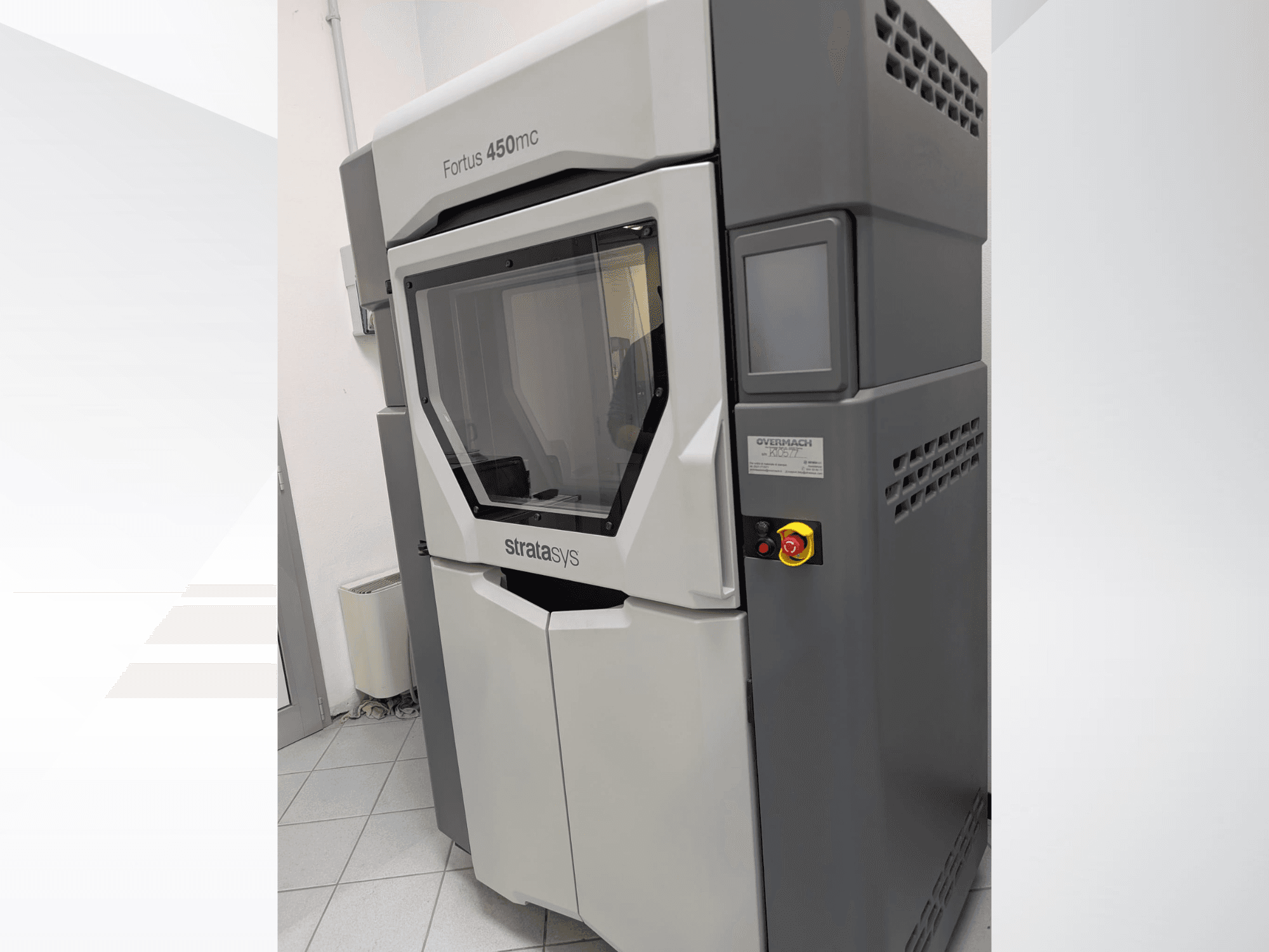 Plastični 3D printer Fortus 450mc prikazan je u bočnom pogledu, s prozirnom prednjom pločom i kontrolnim gumbima sa strane.