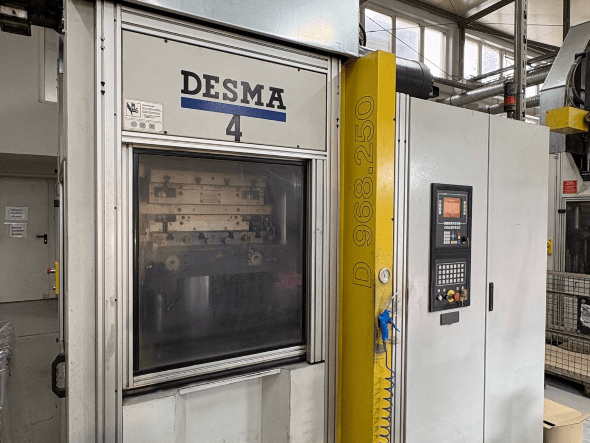 Vertikalni stroj za brizganje plastike Kloeckner Desma 968.250, prednji pogled s upravljačkom pločom i detaljima stroja.