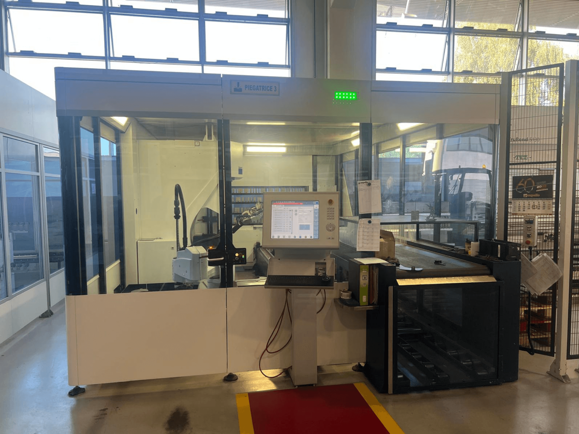 Industrijski stroj za savijanje, model Piegatrice 3, prednji pogled s upravljačkom pločom i robotskom rukom, u dobro osvijetljenom okruženju radionice.