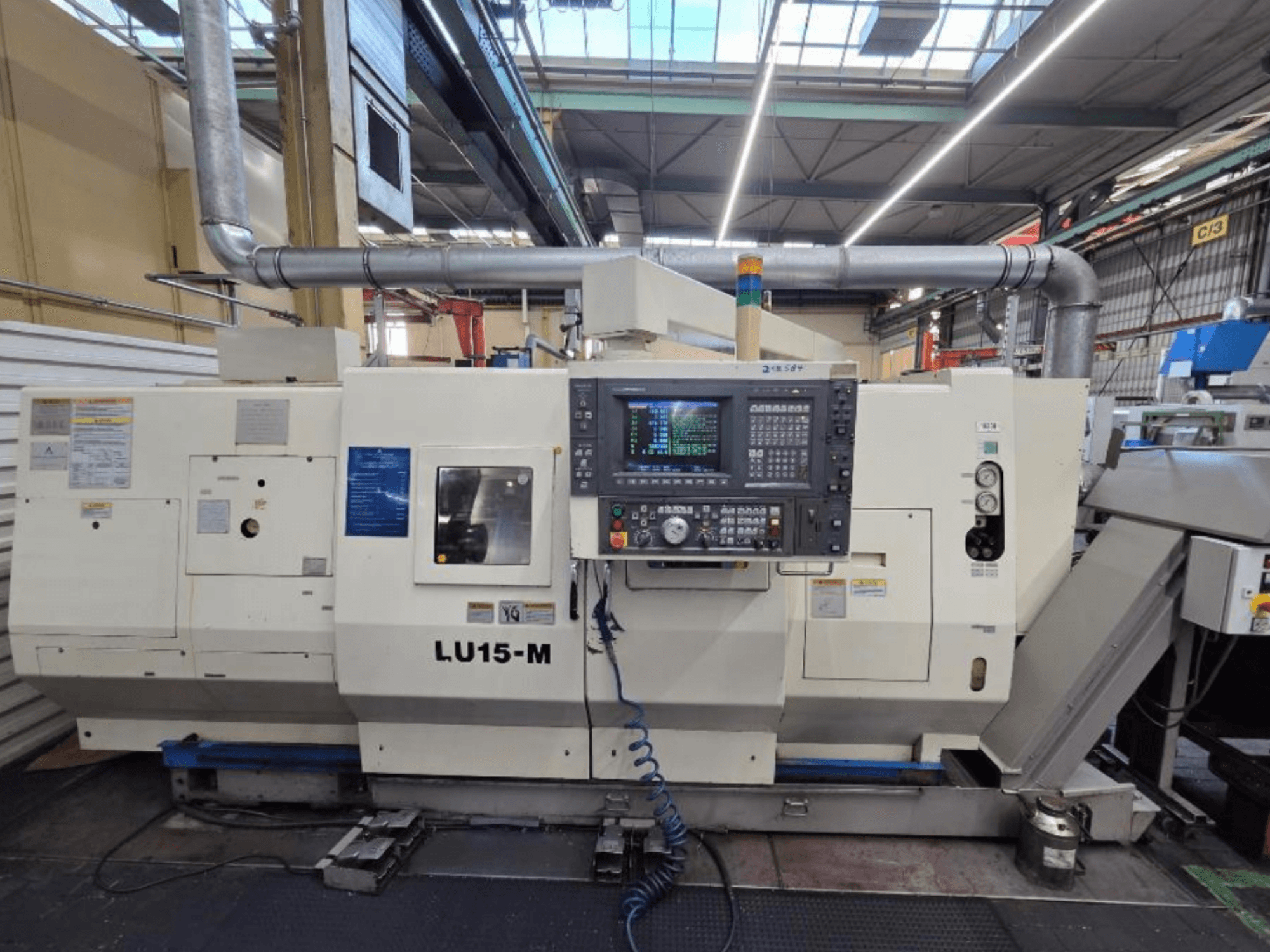 Horizontalni tokarski stroj Okuma LU15 M-2SC 1000, prednji pogled s upravljačkom pločom i značajkama stroja u radioničkom okruženju.