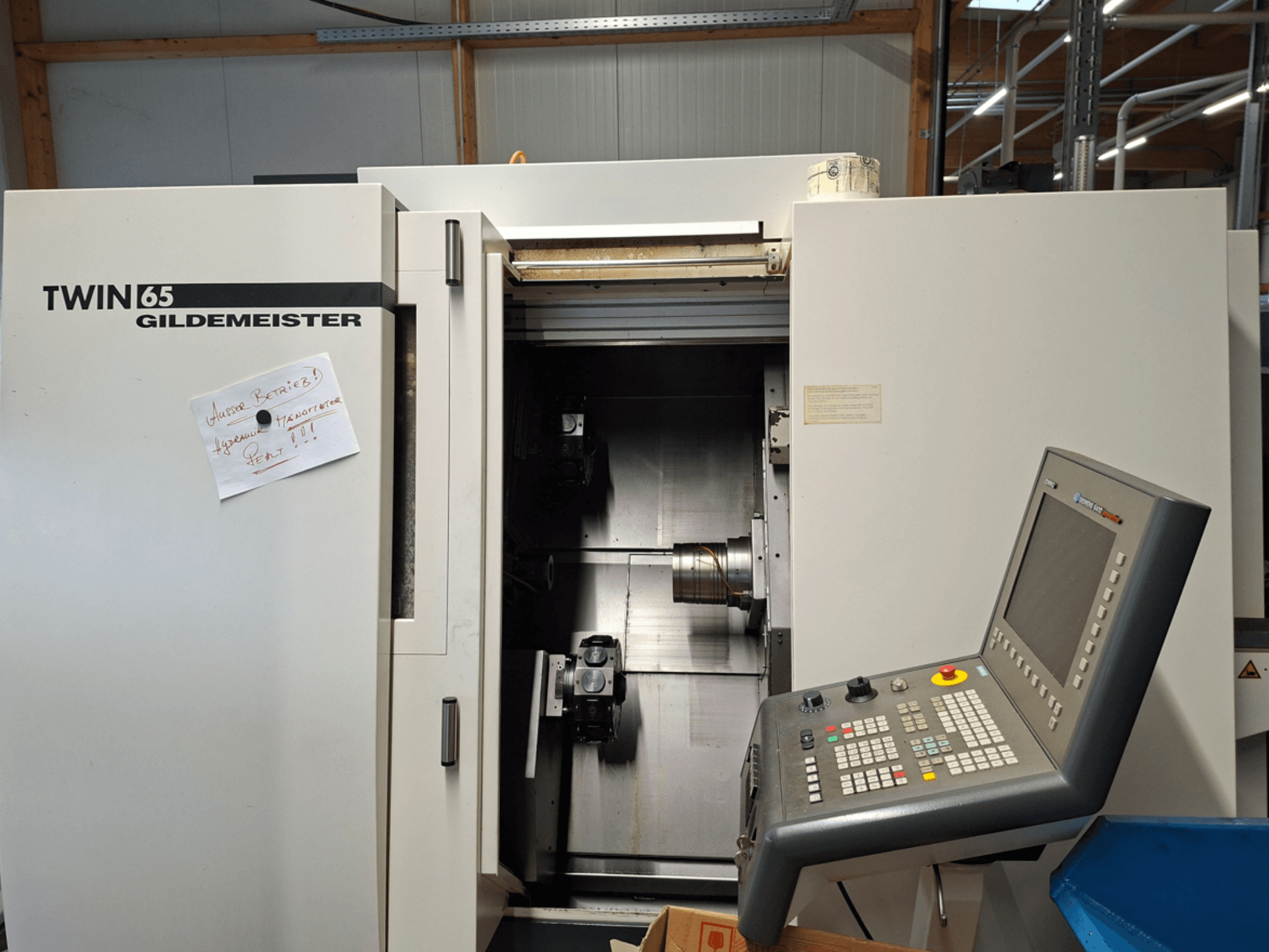 Gildemeister TWIN 65 CNC tokarilica, prednji pogled s upravljačkom pločom i djelomično otvorenom komorom s vidljivim strojevima.