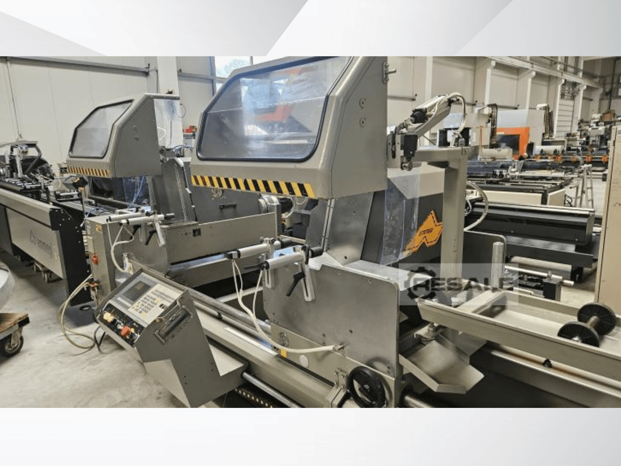 Dvostruke pile u tvorničkom okruženju; prednji pogled s upravljačkom pločom, staklenim poklopcima i komponentama za rezanje.