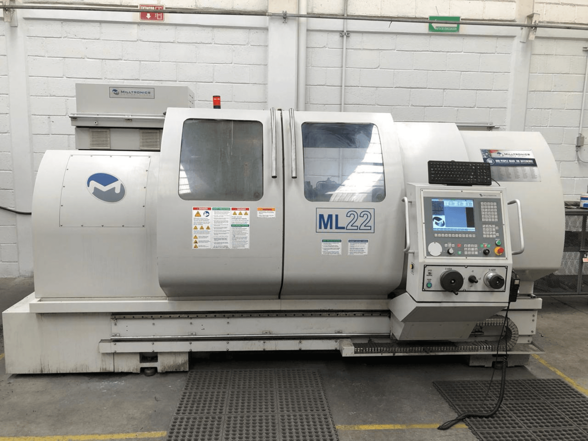 Vertikalni obradni centar MILLTRONICS RH 20, prednji pogled s upravljačkom pločom, logotipom marke i sigurnosnim naljepnicama na stroju.