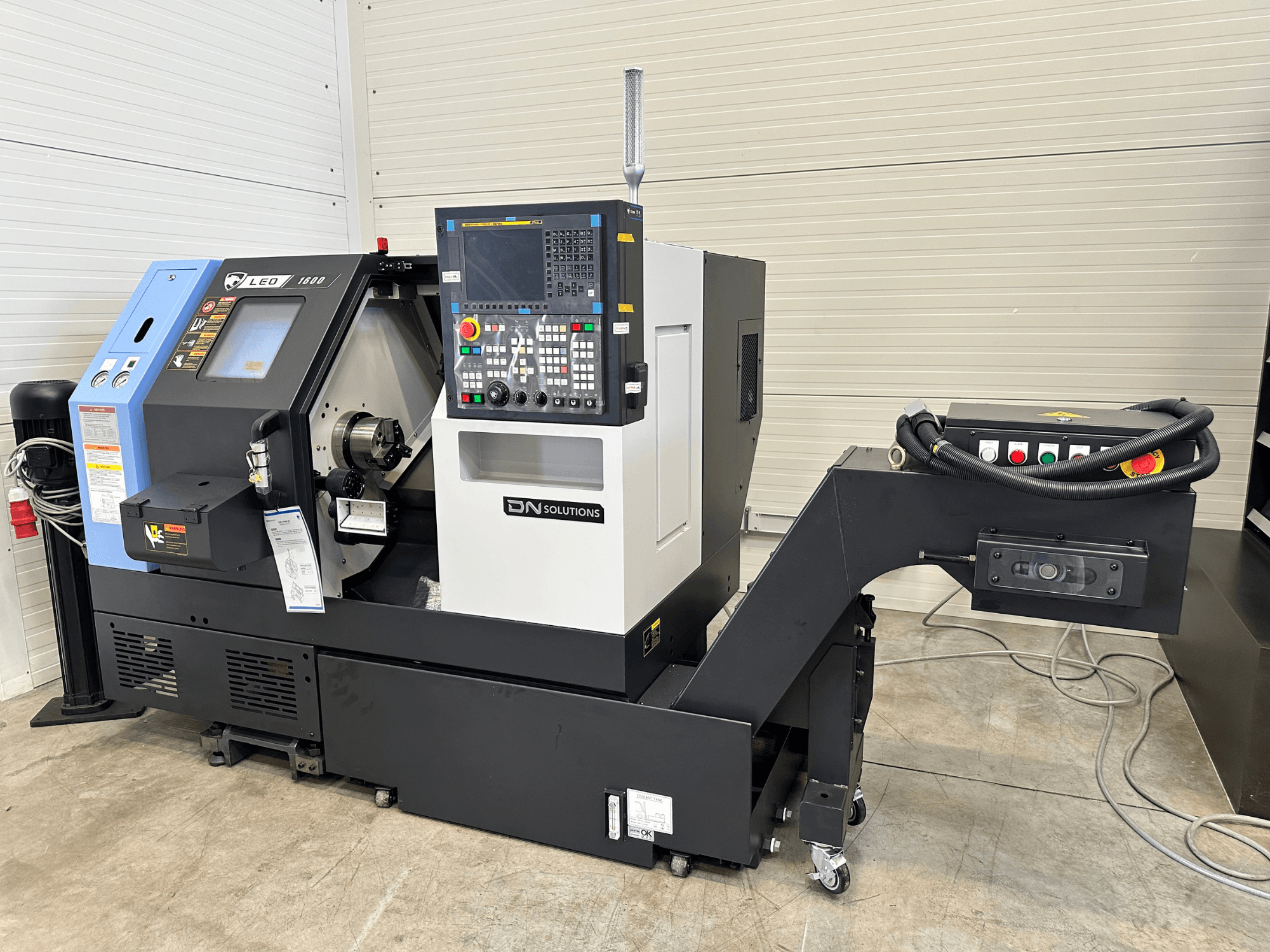 Prednji pogled na DN SOLUTIONS Leo 1600 tokarsko-glodački centar, s digitalnom upravljačkom pločom i držačem alata, na crnoj podlozi.