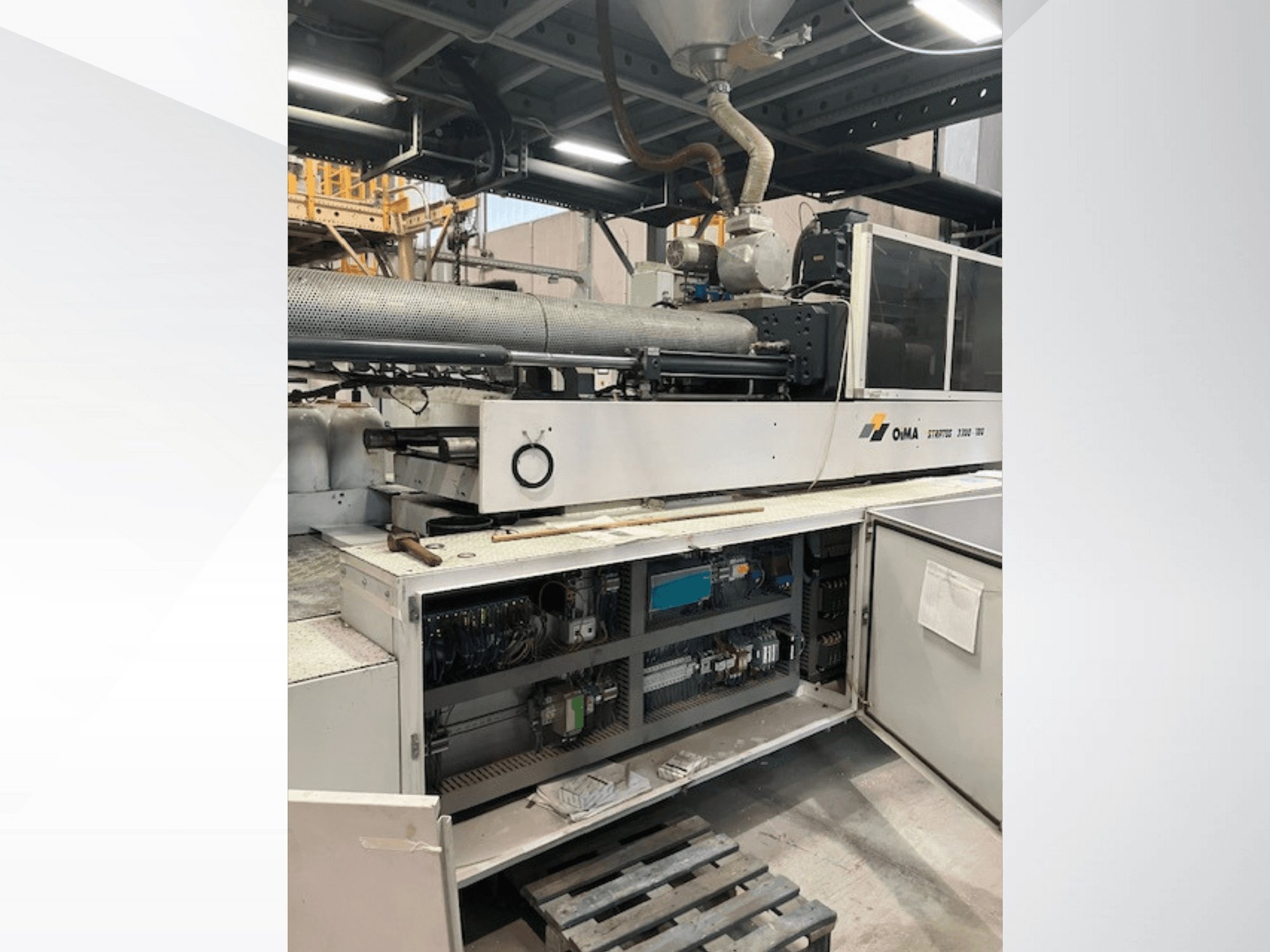 Prednji pogled na OMA Extruder 3500, s prikazom operativnih dijelova, upravljačke ploče i detalja ožičenja. Teški strojevi u industrijskom okruženju.