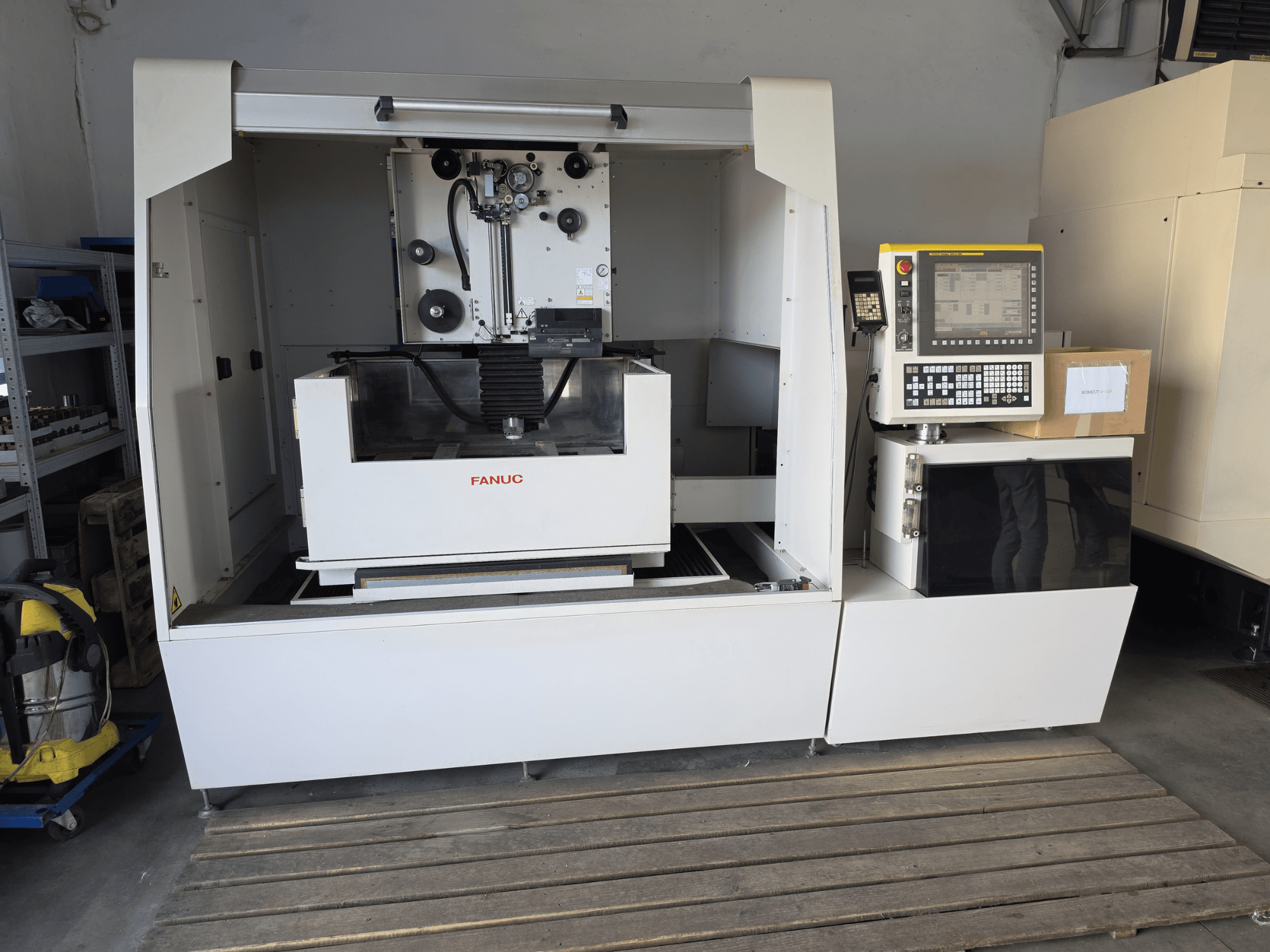 FANUC ROBOCUT alpha-1iD stroj za žičanu eroziju, prednji pogled koji prikazuje upravljačku ploču, radno područje i kompaktni dizajn u radioničkom okruženju.