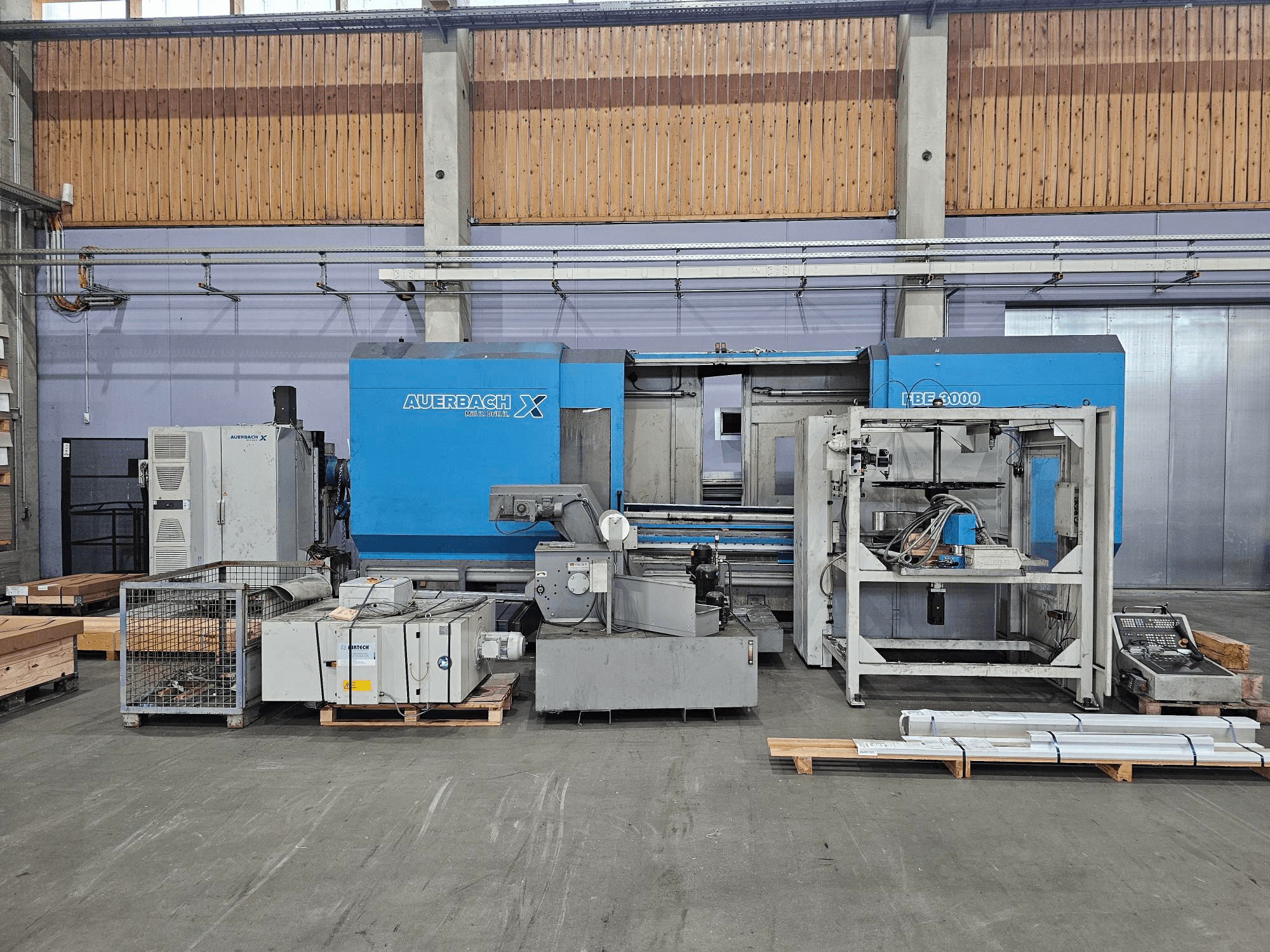 Stroj Auerbach X LBF-3000 u tvorničkom okruženju, bočni pogled, sa sivim i plavim komponentama i vidljivom upravljačkom pločom.