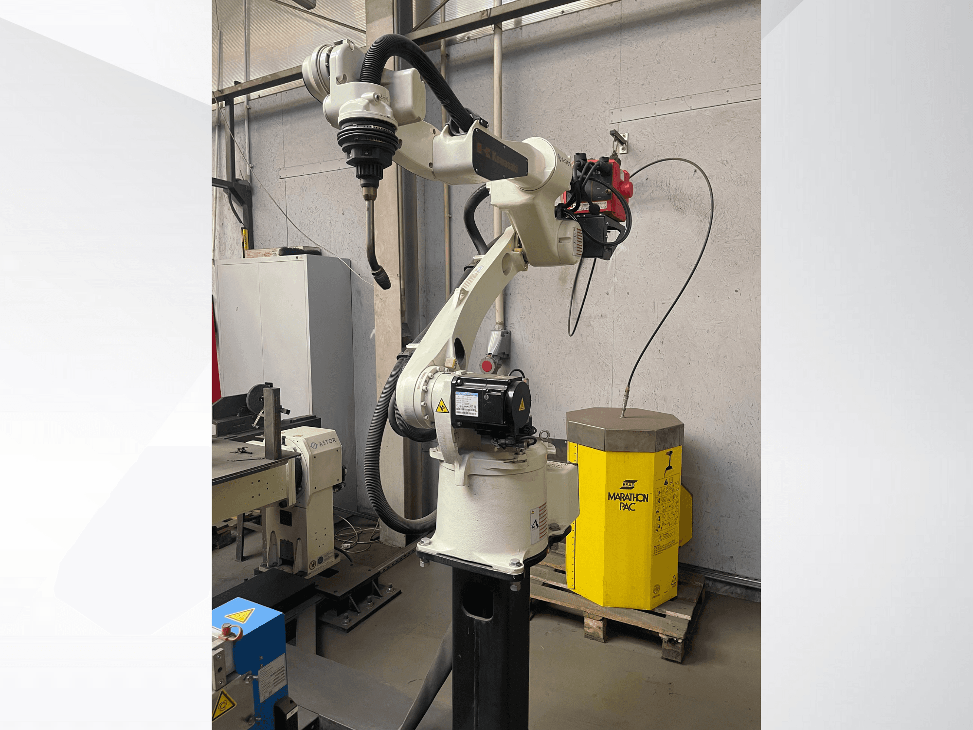 Kawasakijeva robotska ruka iz bočnog pogleda, s montiranim držačem alata, sa žutom pogonskom jedinicom u pozadini.