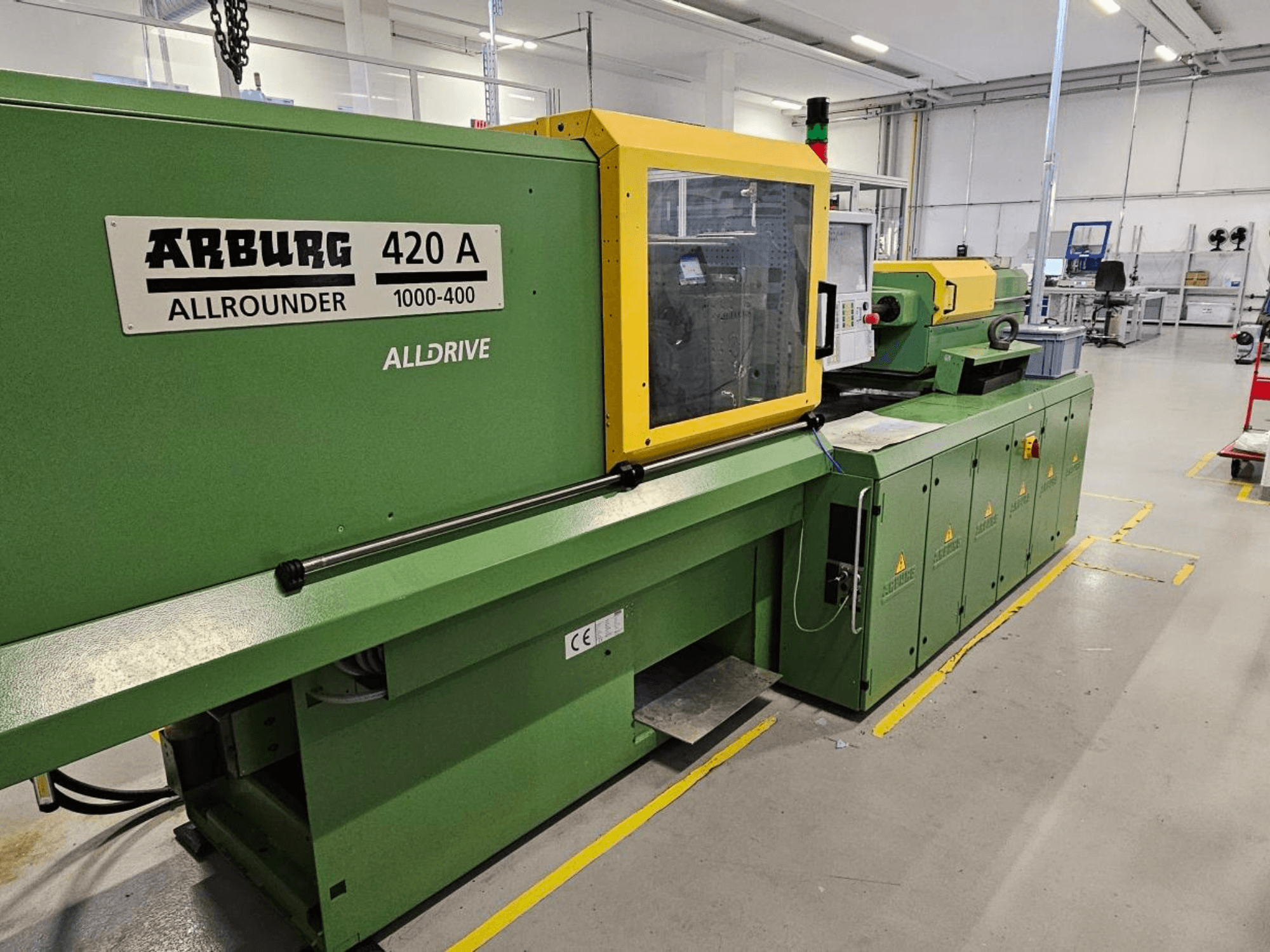 ARBURG 420 A Allrounder 1000-400, prednji pogled; zeleni stroj sa žutom pločom, zaslonom osjetljivim na dodir i sigurnosnim značajkama.