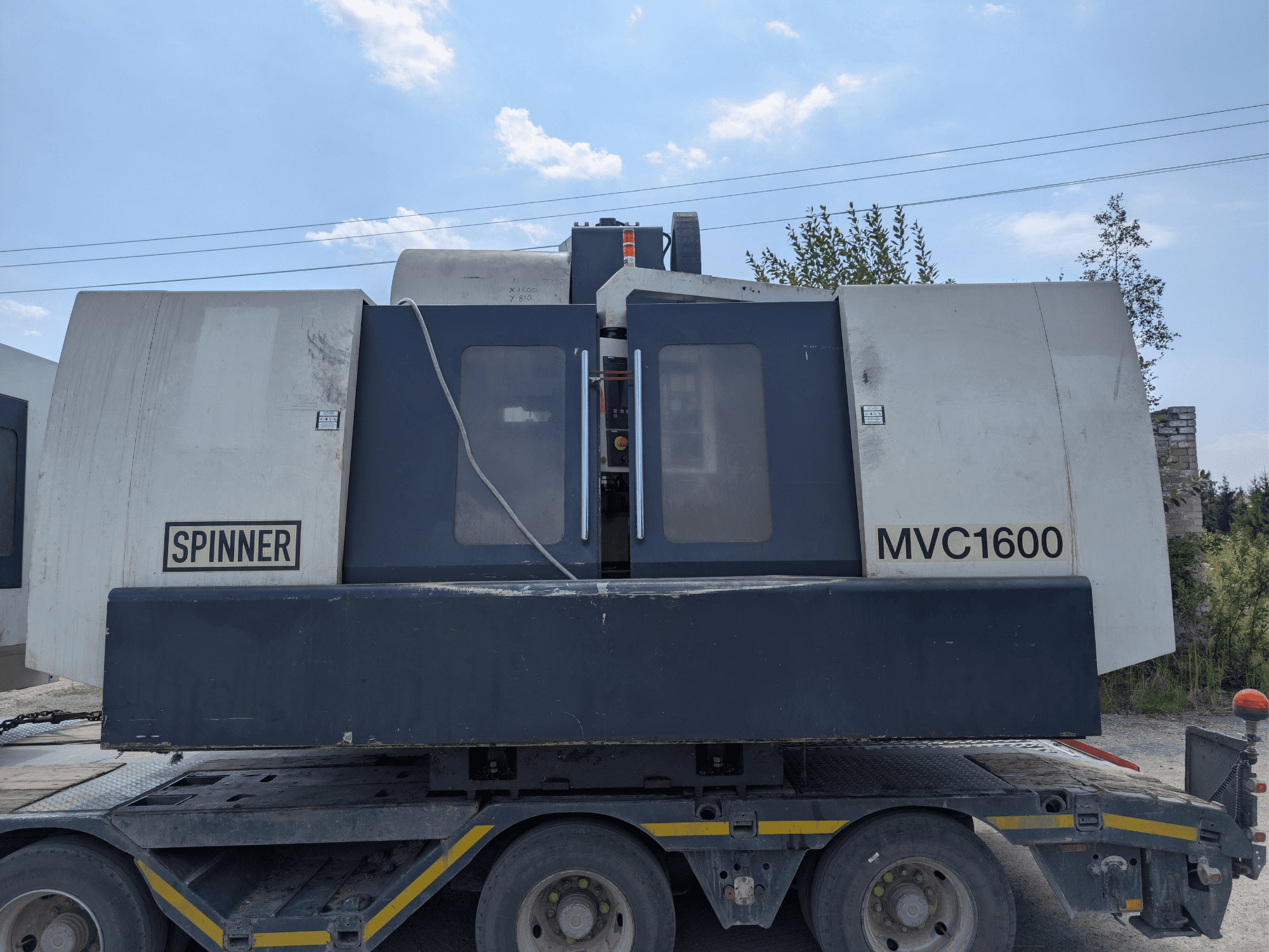Vertikalni obradni centar SPINNER MVC 1600, prednji pogled na kamion, s prikazom brendiranja i velikog područja obrade.