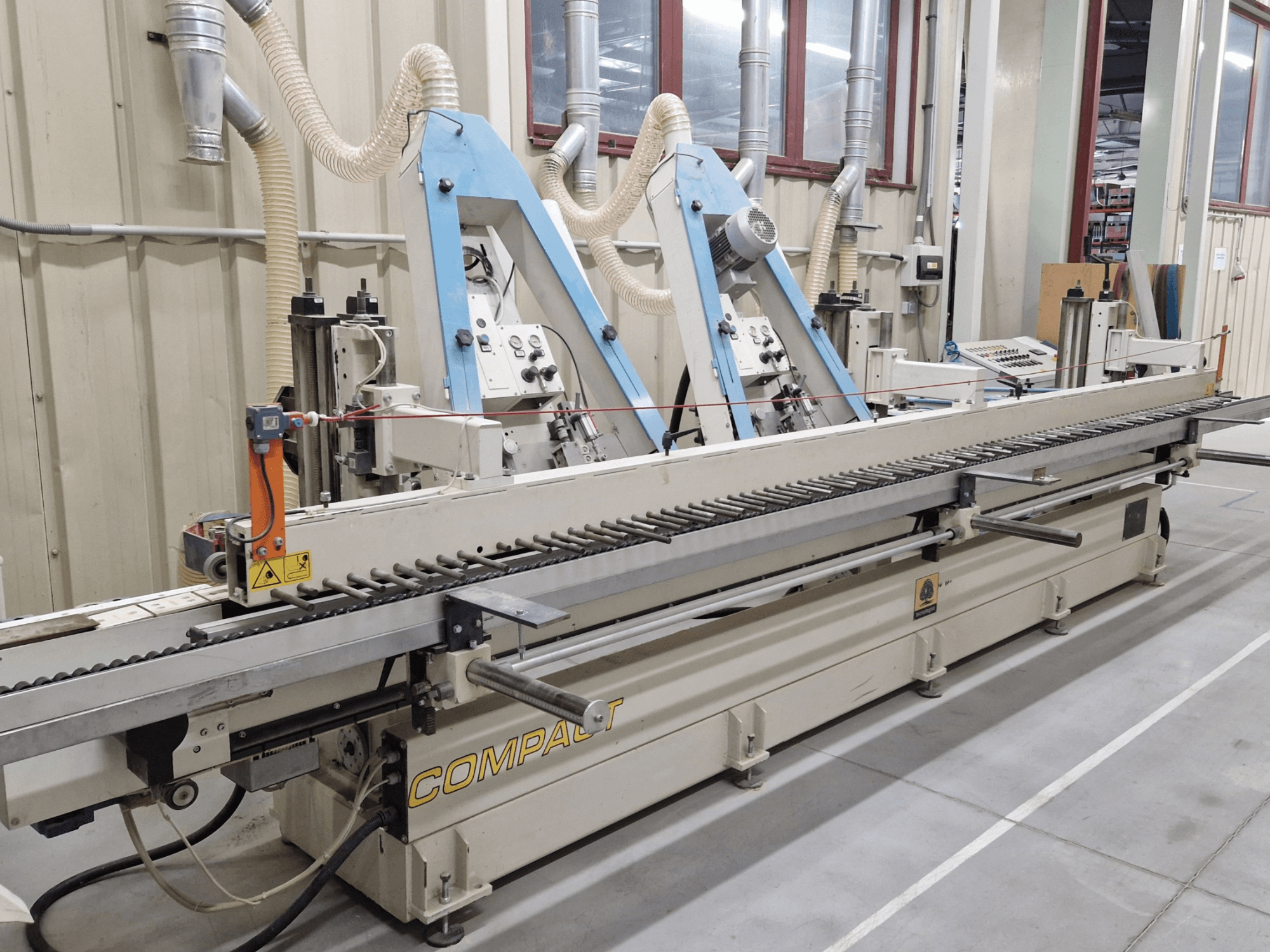 Tračna brusilica TECNOLEGNO COMPACT 52 u radionici, s bočnom slikom upravljačke ploče i mehanizma brusne trake.