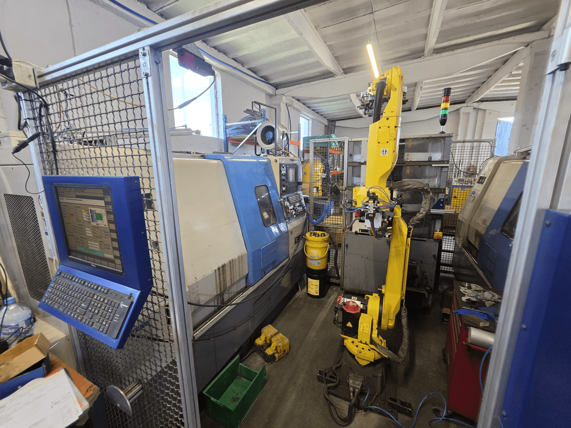 Horizontalni tokarski stroj Hyundai HIT-200C s robotom FANUC M-20iA, prednji pogled s prikazom upravljačkog sučelja i postavki stroja.