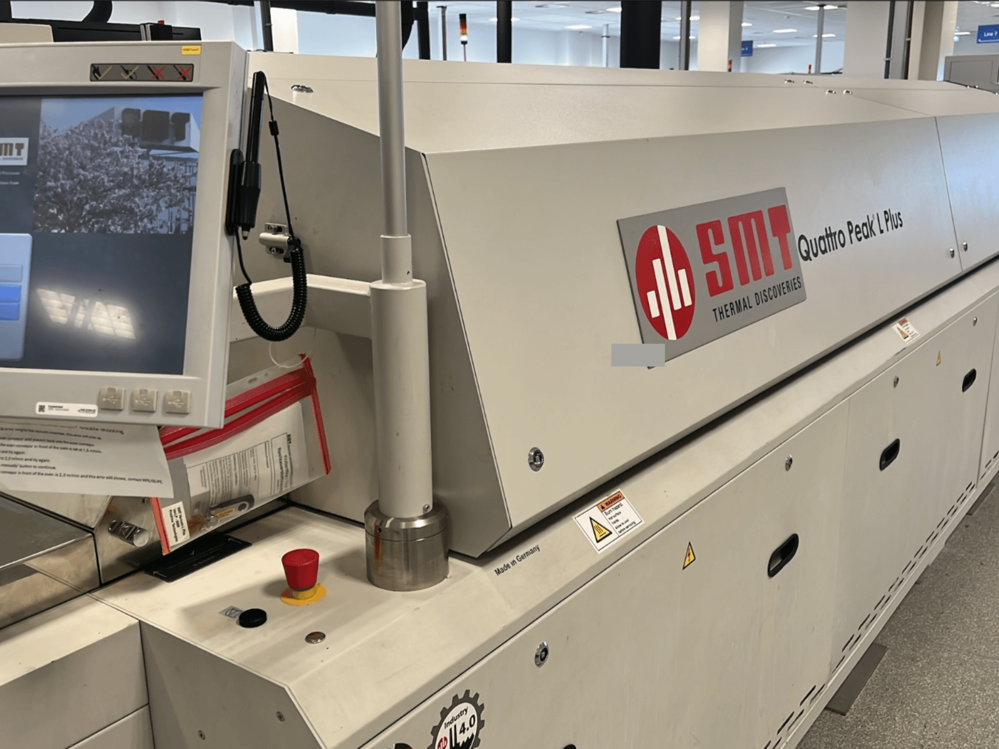 SMT Quattro Peak L Plus alatni stroj, prednji pogled, s jasno vidljivom upravljačkom pločom, sigurnosnim gumbima i brendiranjem.