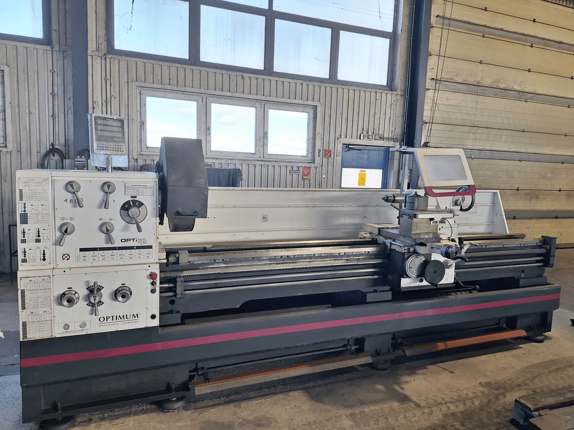 Horizontalni tokarski stroj Optimum OptiTurn TH 8030D u bočnom pogledu, s upravljačkom pločom, držačem alata i čvrstim postoljem.