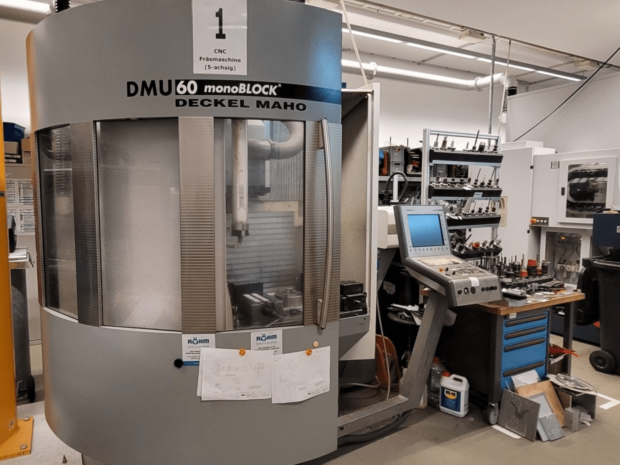 CNC glodalica DECKEL MAHO DMU 60 monoBLOCK u prednjem pogledu, s upravljačkom pločom i spremištem alata pored nje.