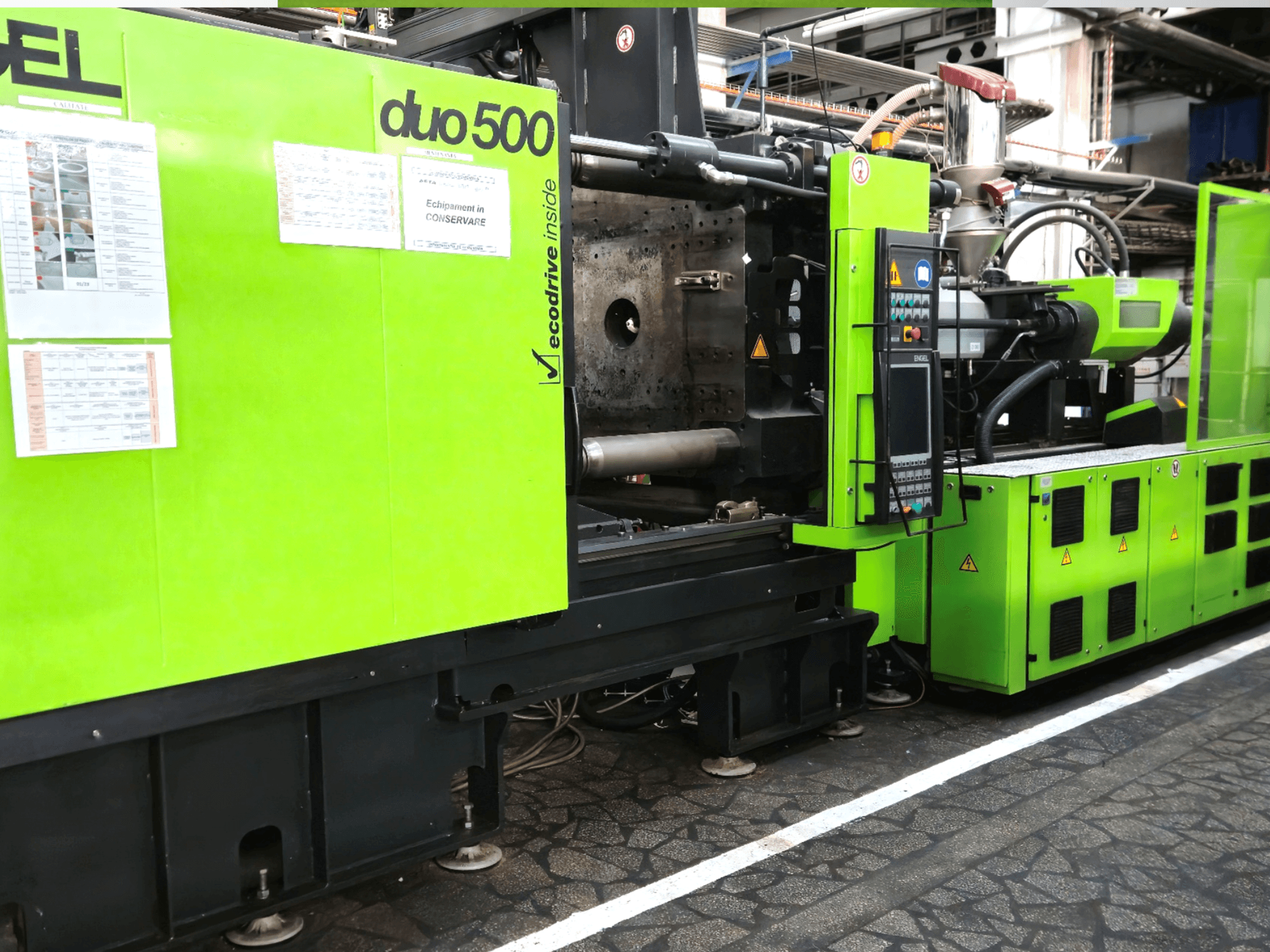 Zeleni industrijski stroj Ergotron duo 500, prednji pogled; s upravljačkom pločom, tehničkim detaljima i sigurnosnim naljepnicama za opremu.