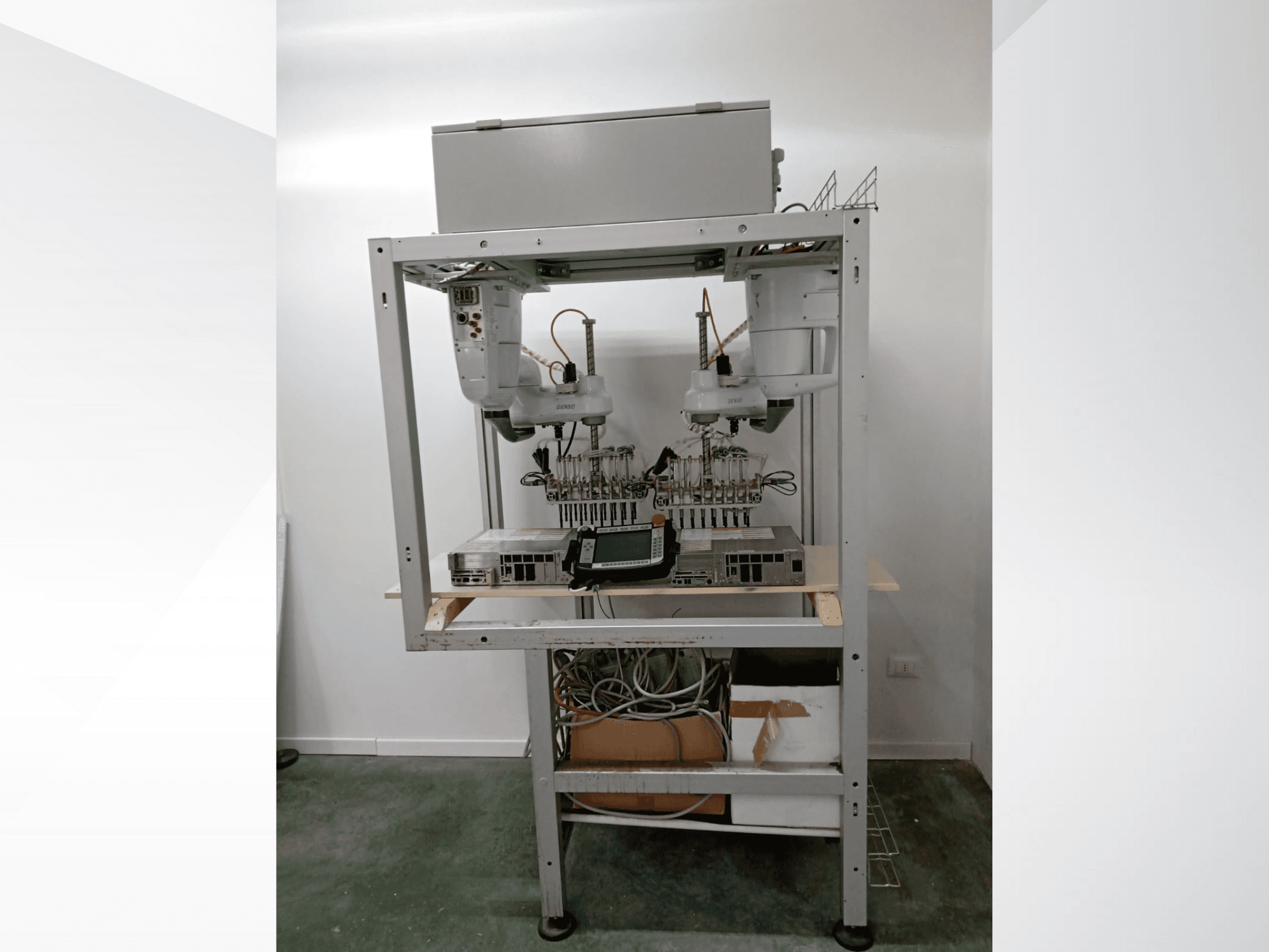 Automatizirana robotska radna stanica s dvostrukim rukama, zaslonom i elektronikom na metalnom okviru, prednji pogled, napredna tehnološka postavka.