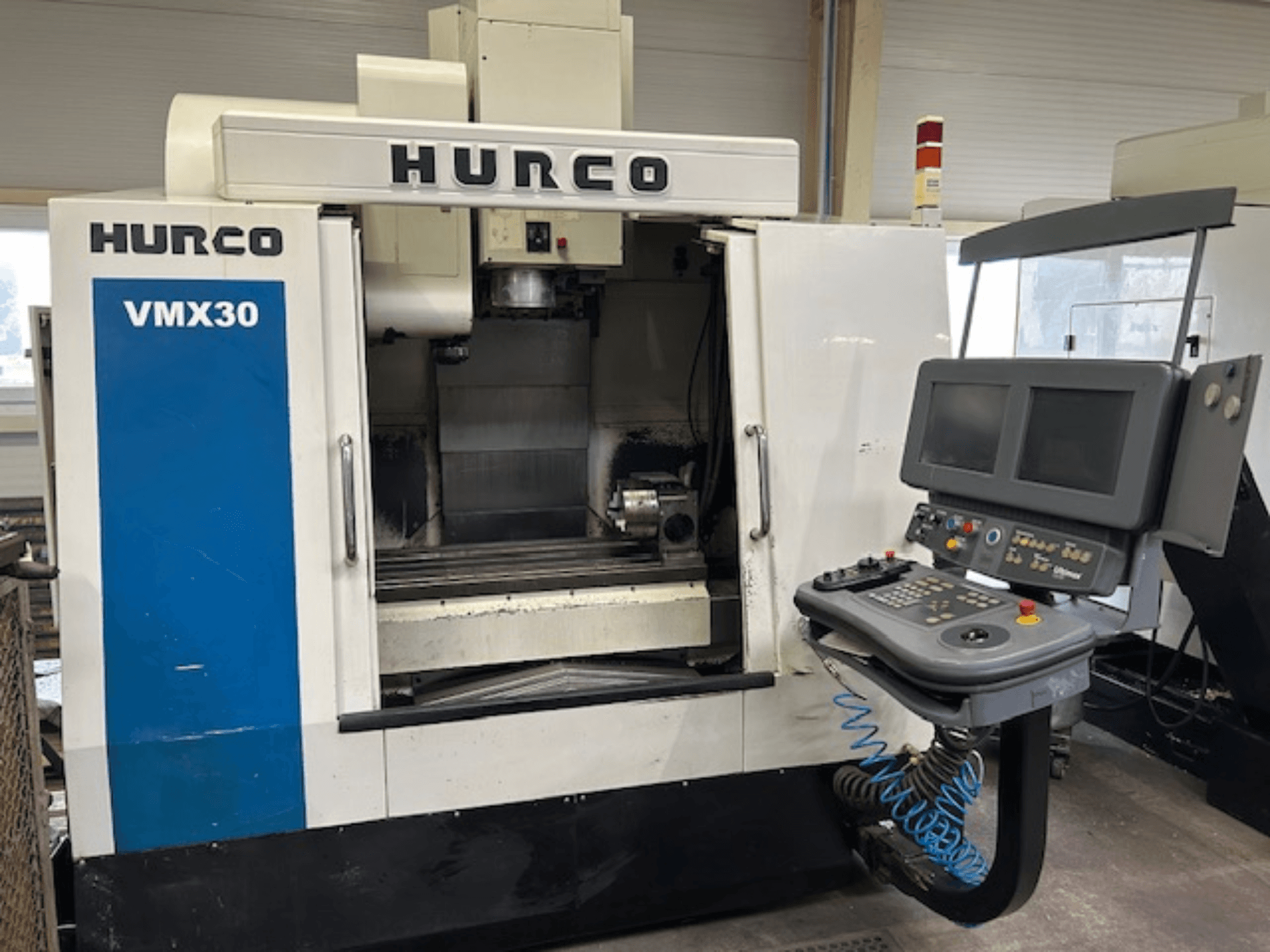 Hurco VMX30 CNC glodalica u radionici, prednji pogled; ima upravljačku ploču s dvostrukim ekranima i operativnim tipkama.