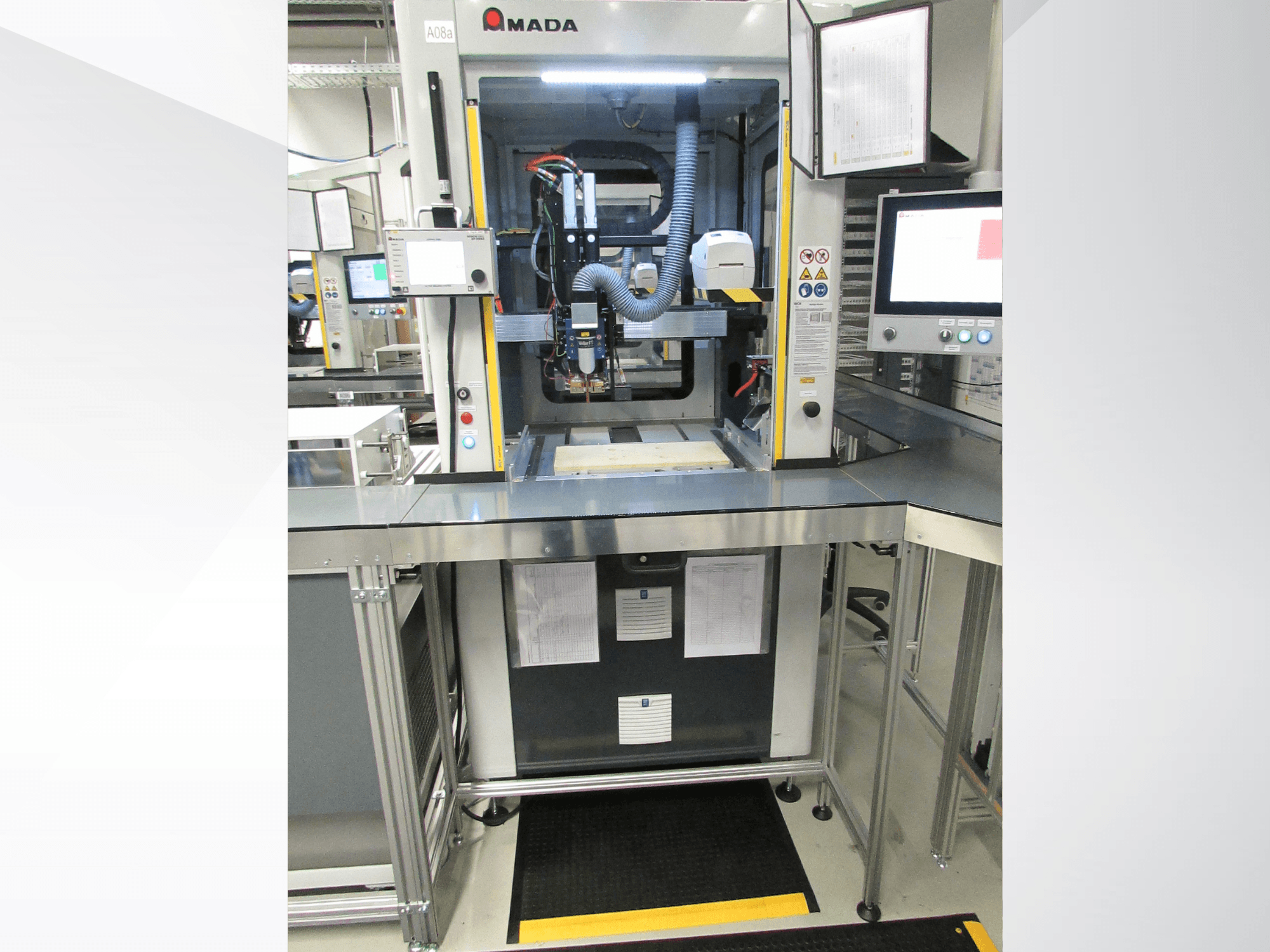 Prednji pogled na automatizacijski stroj AMADA Jupiter System s kontrolama, monitorom i čistim radnim prostorom za rad.