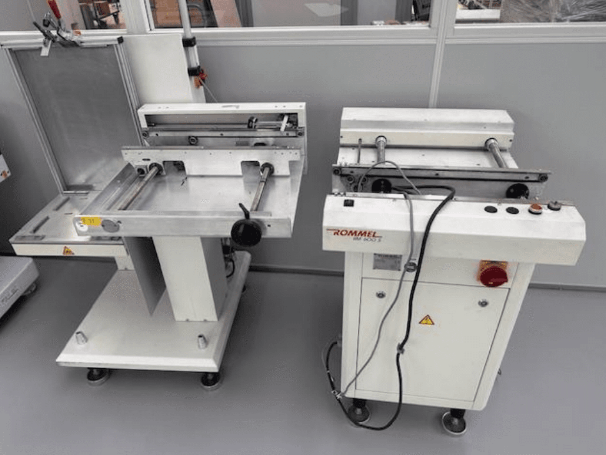 Stroj za etiketiranje Rommel HM 5033, pogled sprijeda; ima upravljačku ploču, valjke i površine od nehrđajućeg čelika.