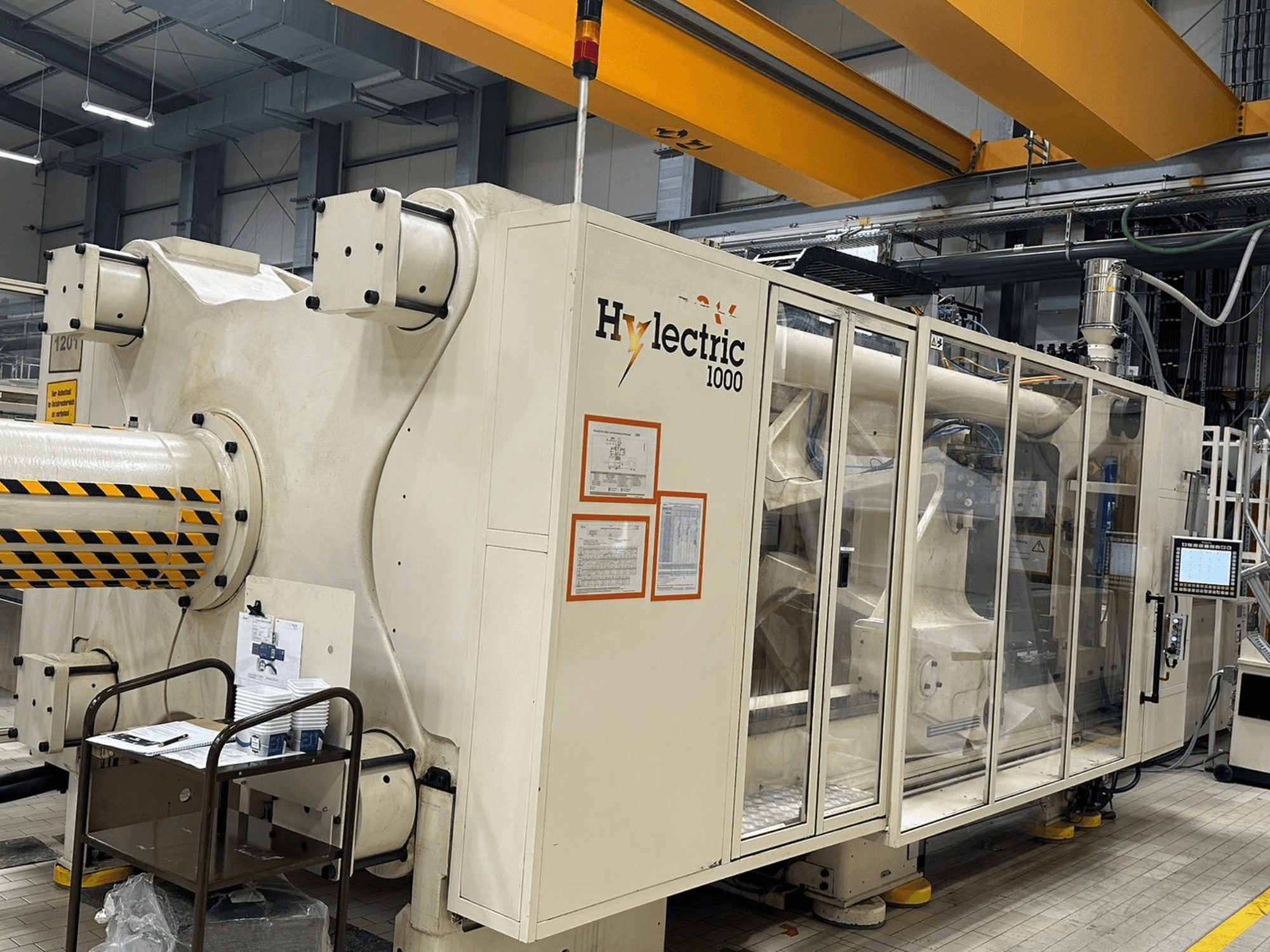 Električni stroj za brizganje plastike Husky Hylelectric H1000 RS95/80, bočni pogled s vidljivom upravljačkom pločom i sigurnosnim značajkama.