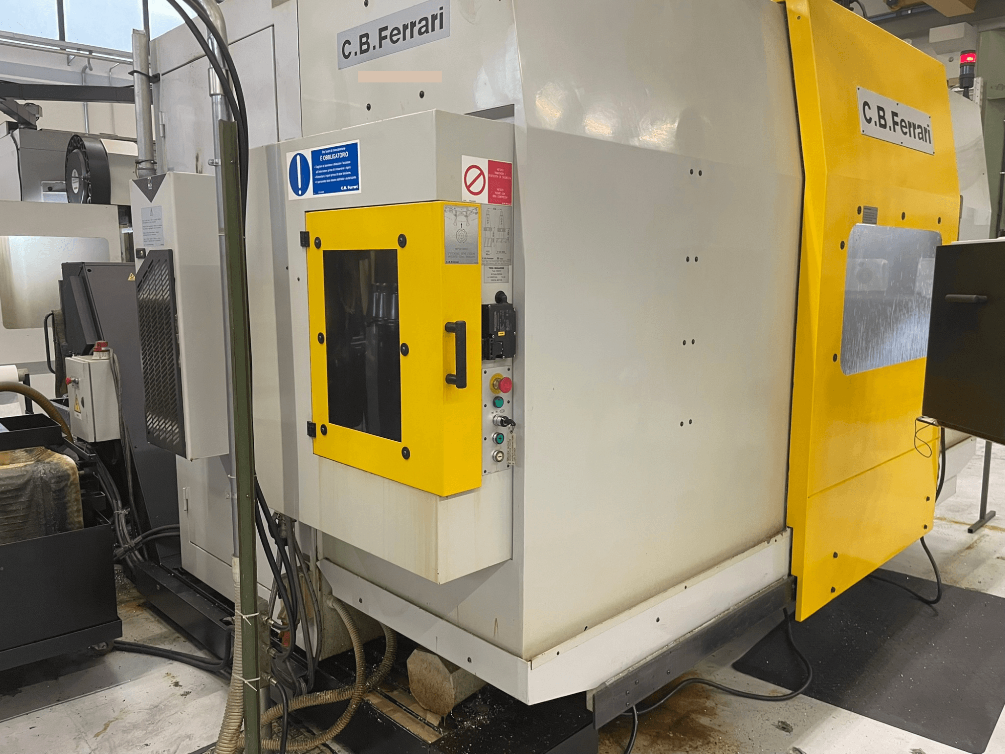 Industrijski stroj CB Ferrari, prednji pogled; ima žuta vrata, upravljačku ploču i vidljive komponente za obradu.