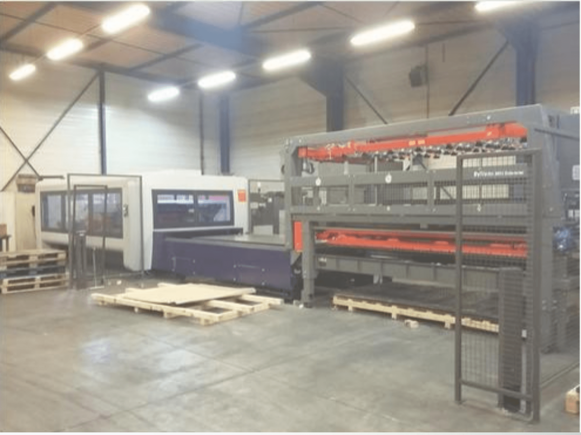 Postavljanje industrijskih strojeva u skladištu; uključuje sivi laserski rezač i ljubičasti CNC usmjerivač, prednji pogled s paletama.