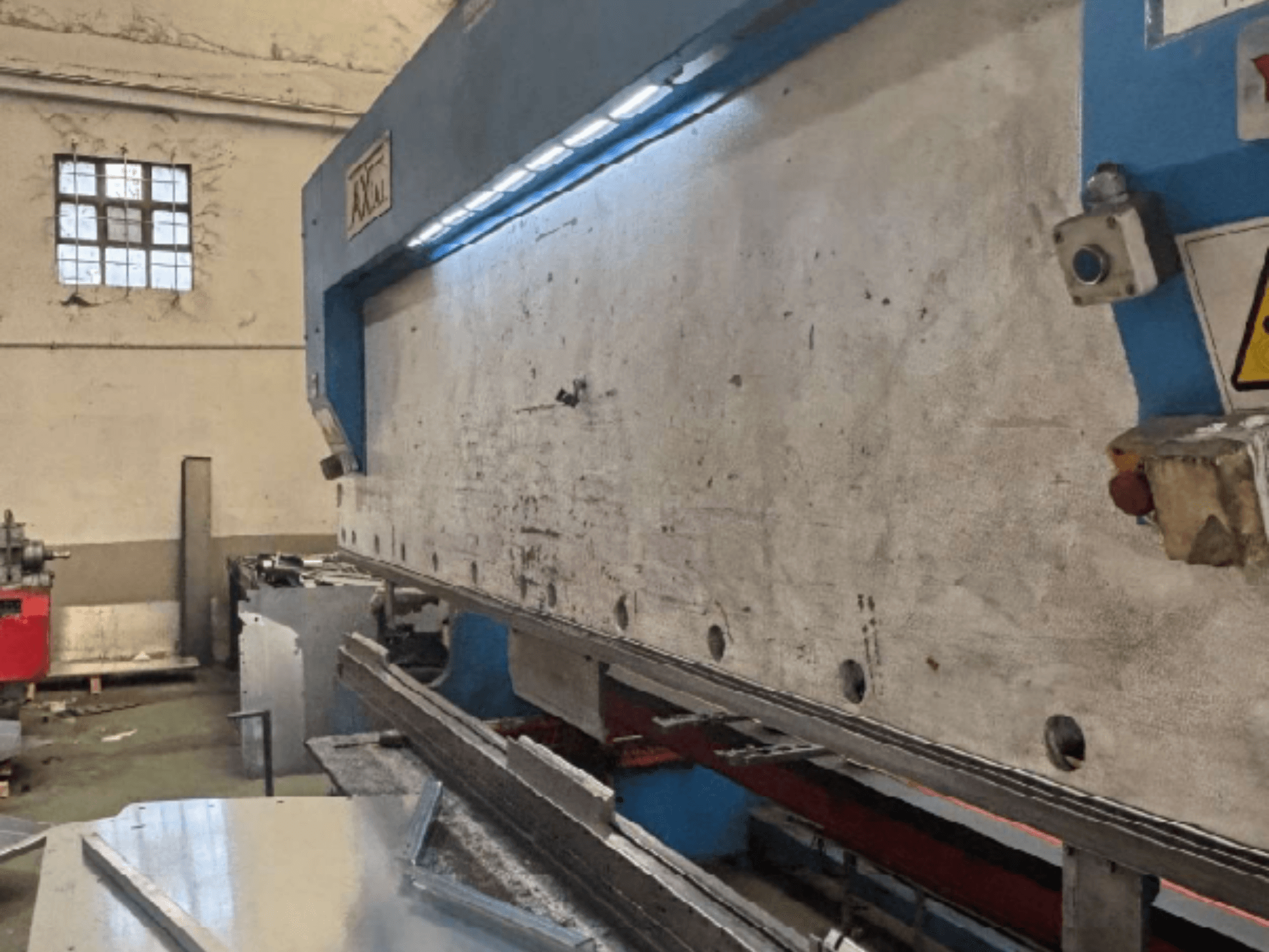 Aksijalni sustav za rukovanje paletama PHS-W-124 u radionici, bočni pogled s detaljima radne površine i upravljačke ploče.