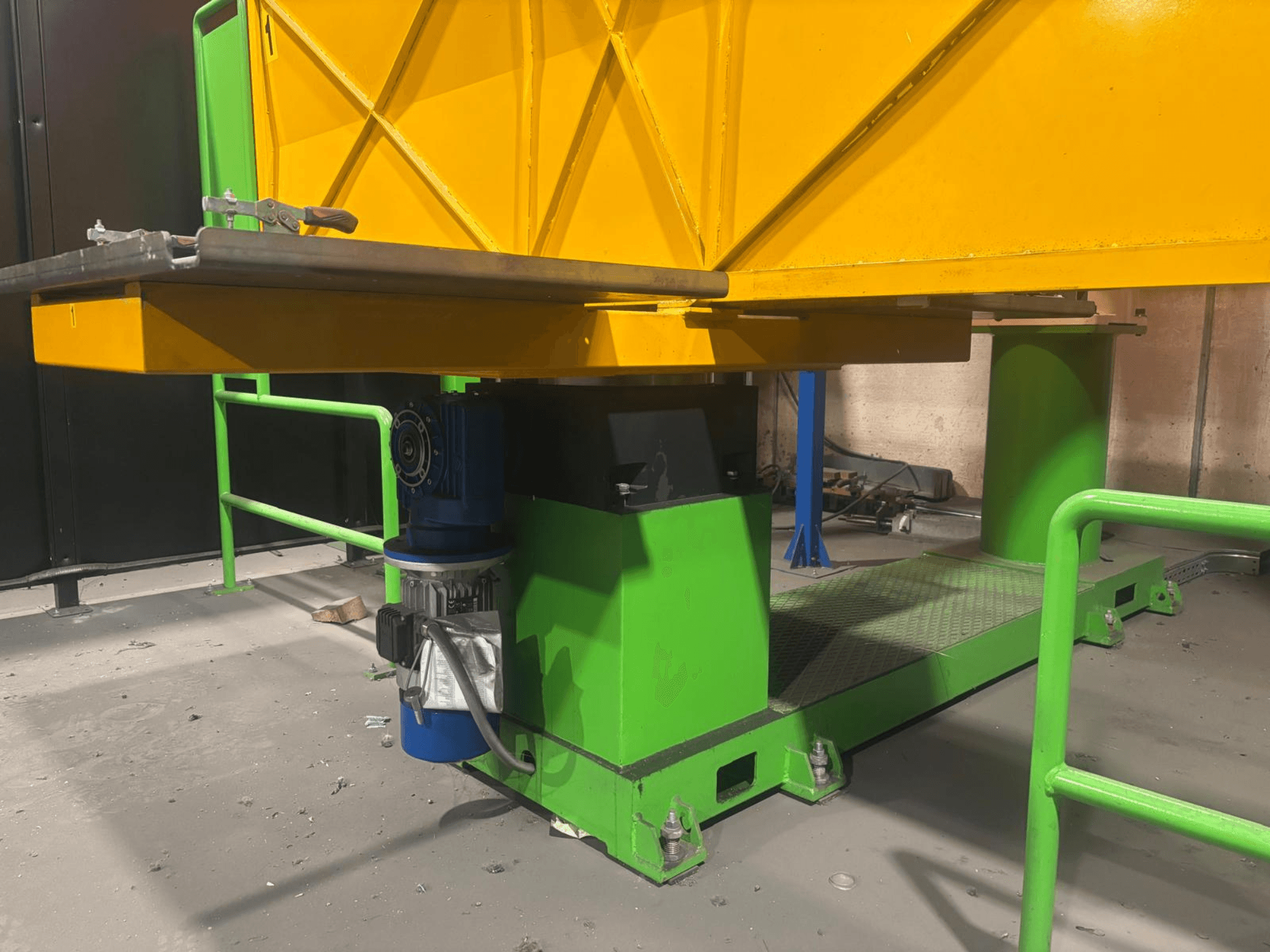 Zeleni i žuti industrijski strojevi iz niskog prednjeg pogleda, s motorom i platformom s teksturiranom površinom.