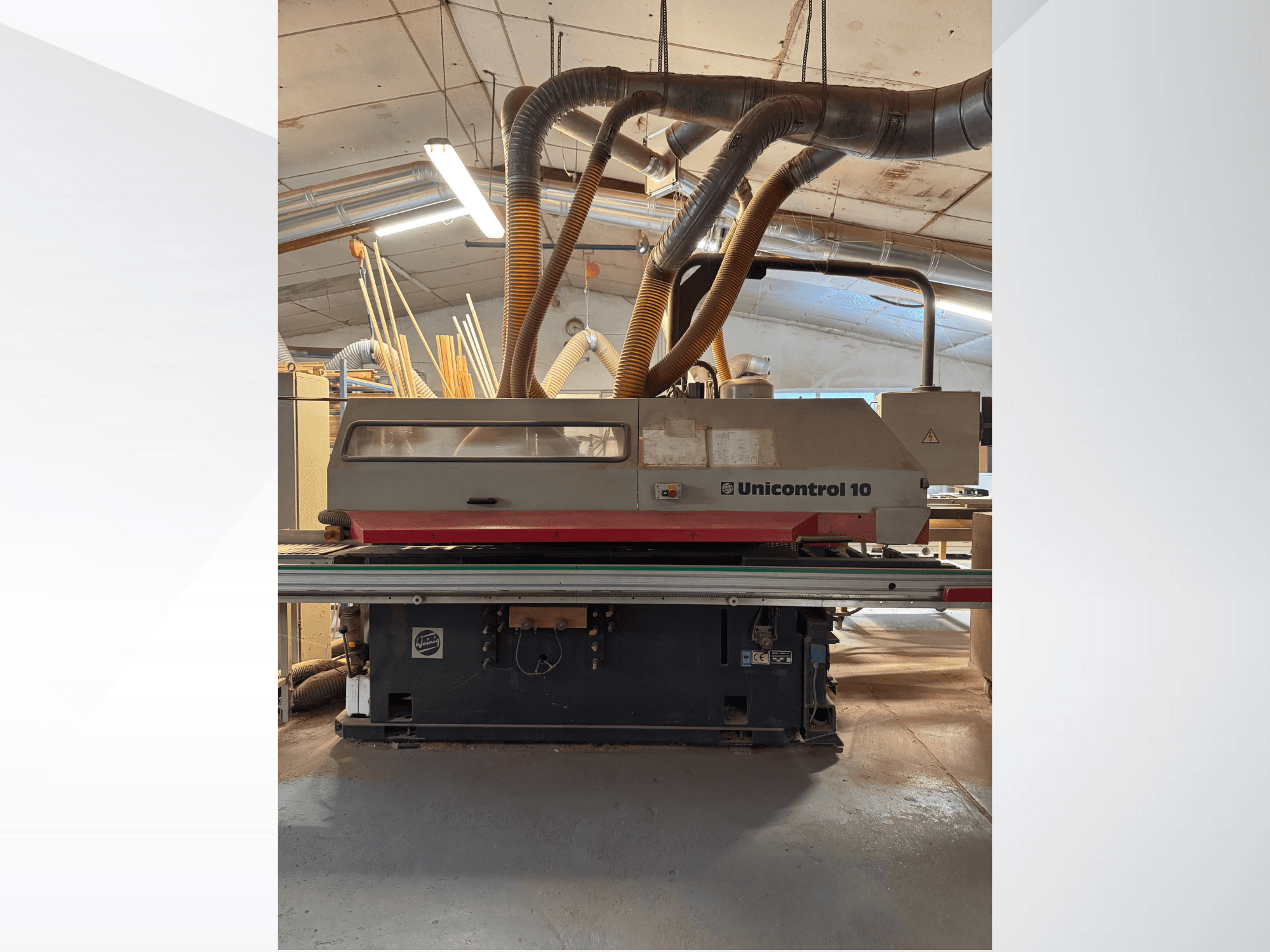 Prednji pogled na stroj za obradu drveta Unicontrol 10, s cijevima za usisavanje prašine i upravljačkim elementima.