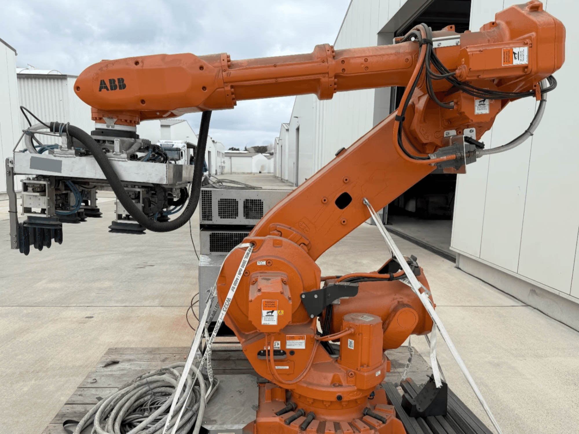 Bočni pogled na robotsku ruku ABB RB 6600-130/3.2, s narančastom robotskom rukom s hvataljkom i vidljivim ožičenjem.