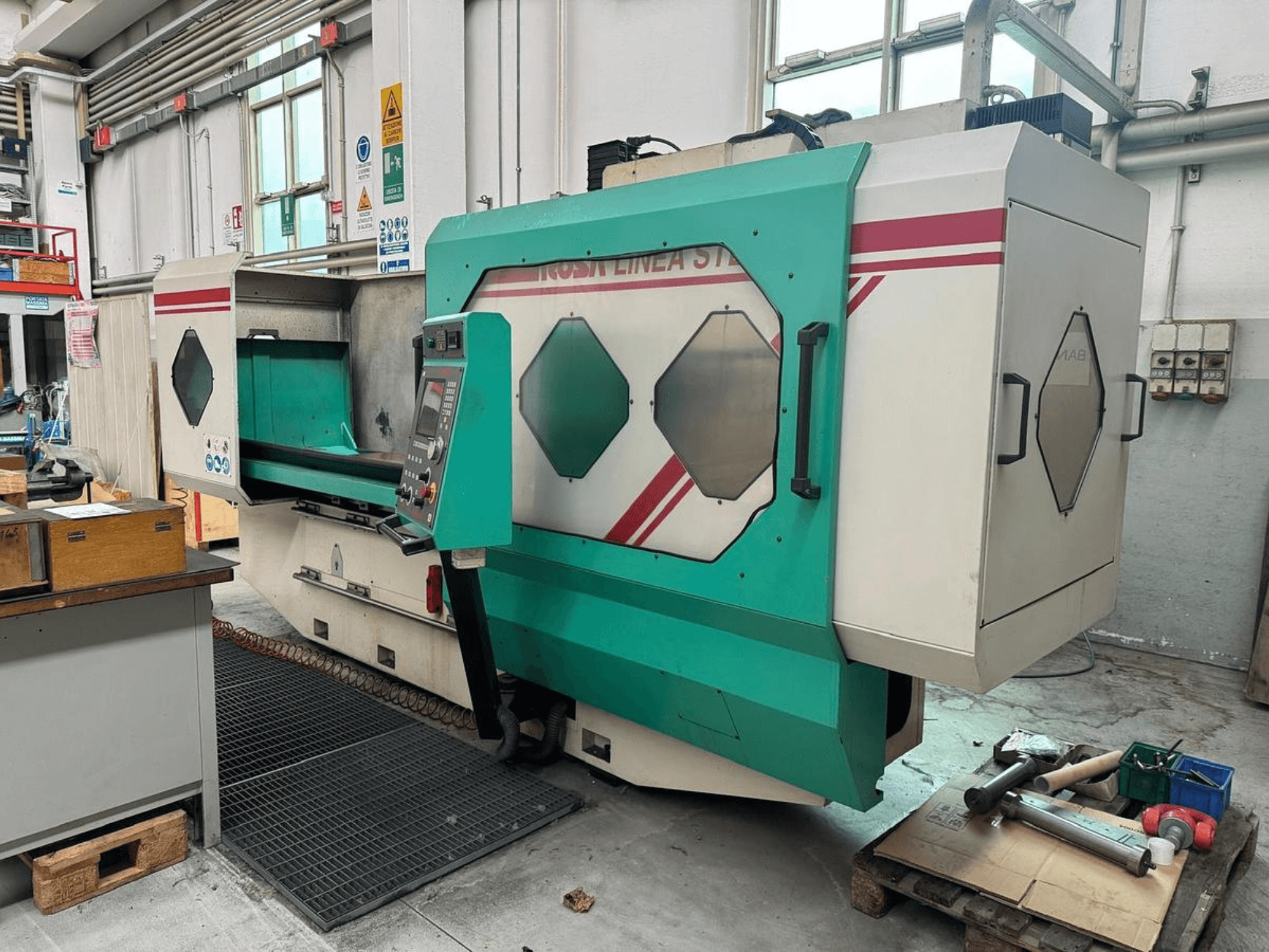 Zeleno-bijeli precizni stroj, prednji pogled, s upravljačkom pločom, radnim prostorom i alatima na paleti. Marka: BAMB.