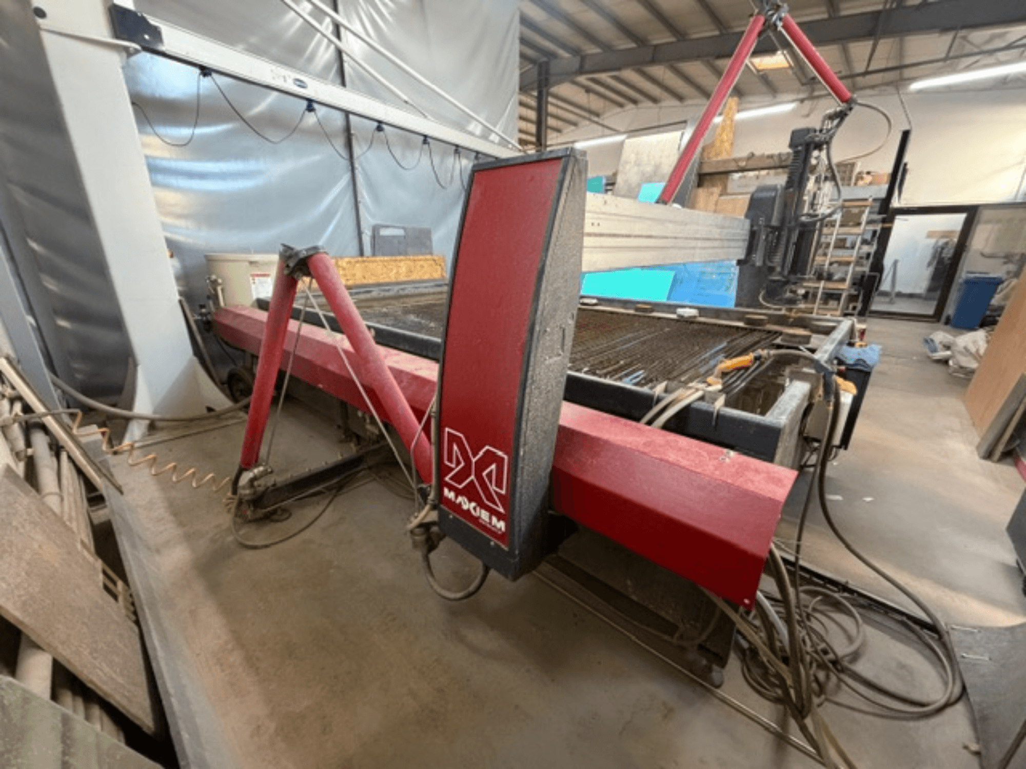 Crveni stroj za rezanje vodenim mlazom marke X, gledan sa strane, s prikazom mehaničkih komponenti i detalja cijevi.