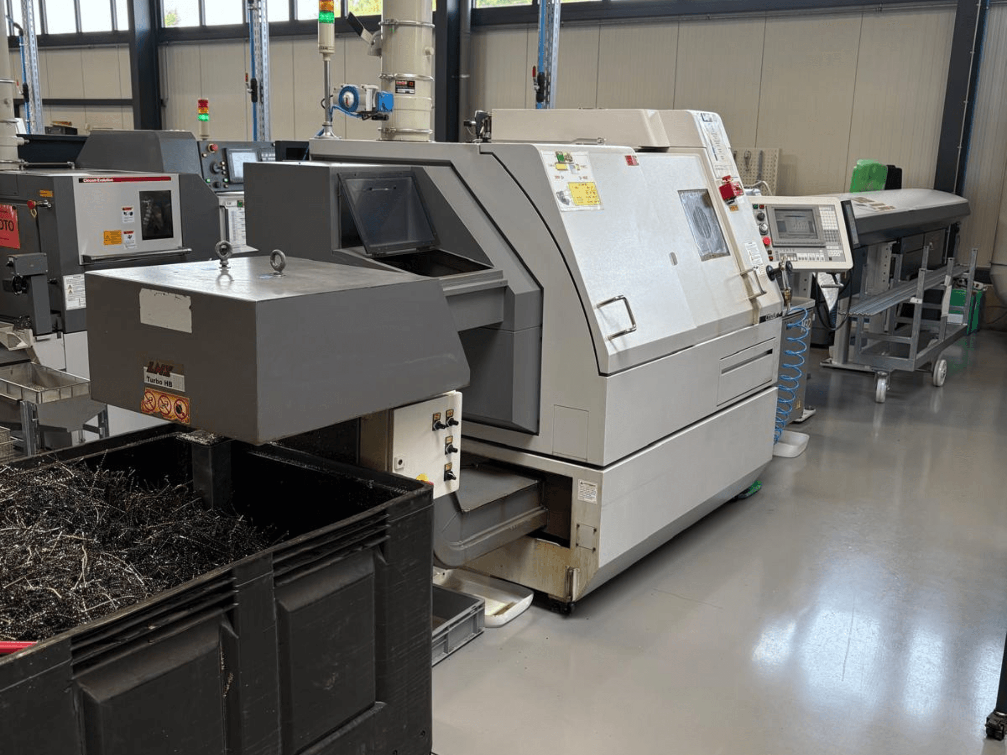 Industrijski stroj LTA Turbo H8, bočni pogled, s velikim spremnikom za metalne strugotine i upravljačkom pločom u tvorničkom okruženju.