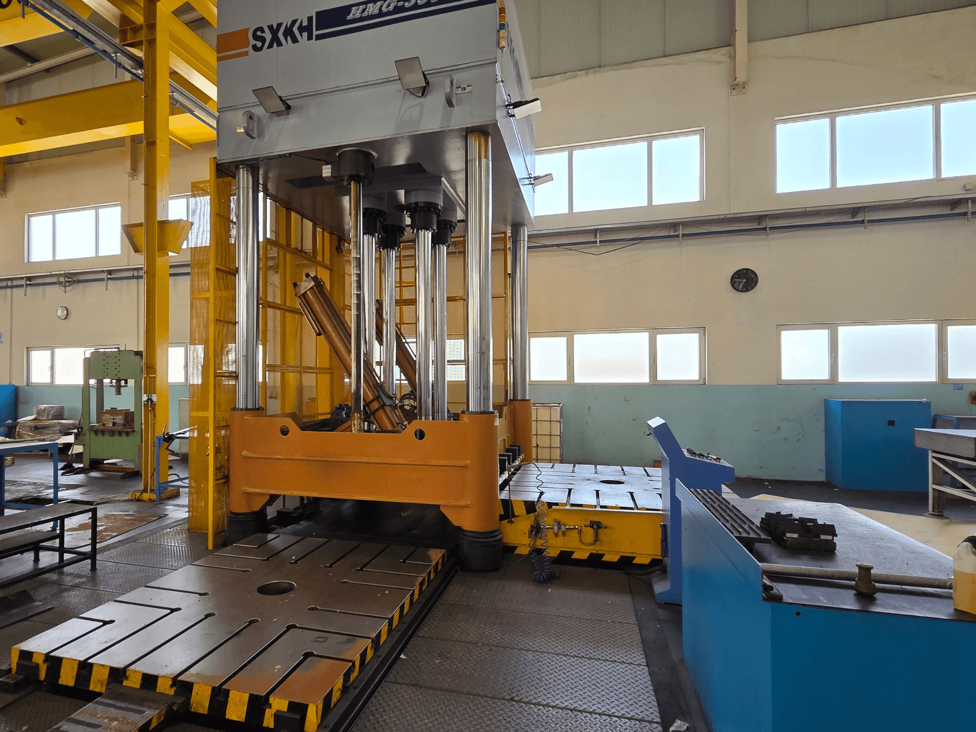 Hidraulična preša SXKH HMG-300JM, prednji pogled, s velikim cilindrima za prešanje i robusnom bazom u tvorničkom okruženju.