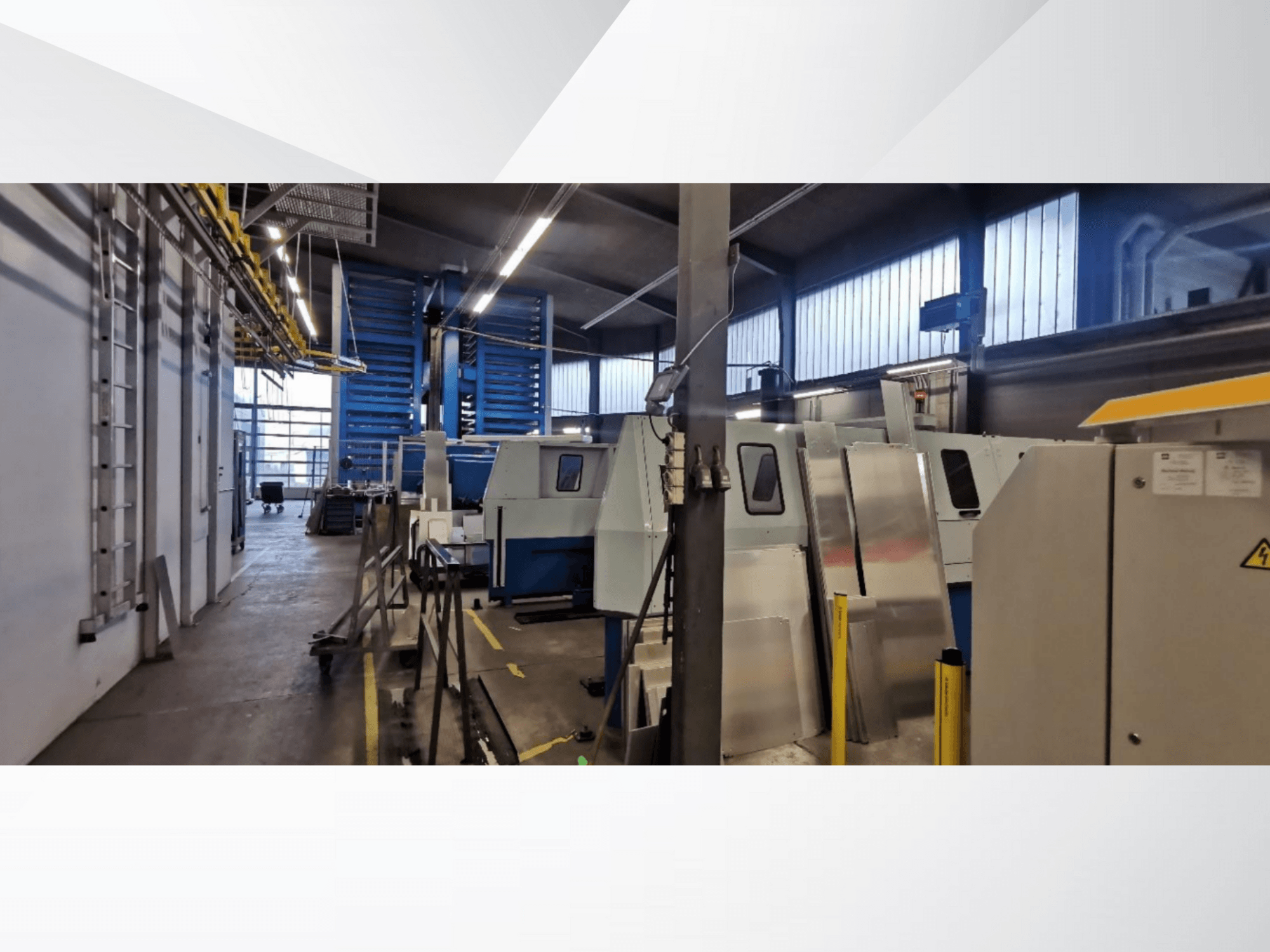 Industrijska radionica s bočnom slikom nekoliko strojeva i opreme, s metalnim površinama i vidljivim sigurnosnim elementima.