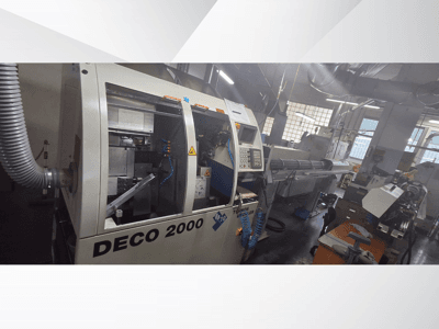 DECO 2000 CNC stroj u radionici, pogled sprijeda, s desne strane prikazane su kontrole i postava dugog obratka.