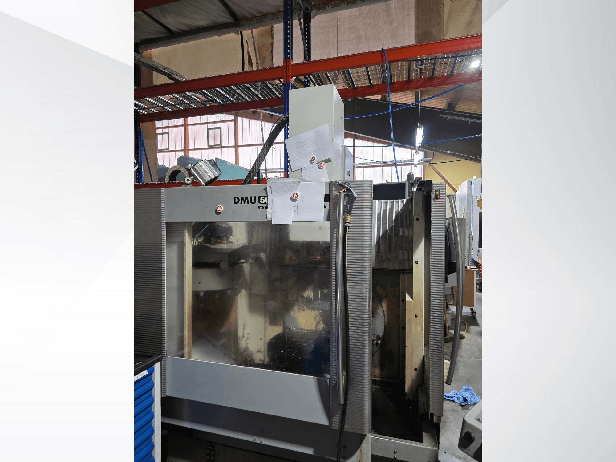 DMU 50 3-osni CNC obradni centar u radionici, prikazan s prednje strane, s prikazom operativnih komponenti i priložene dokumentacije.