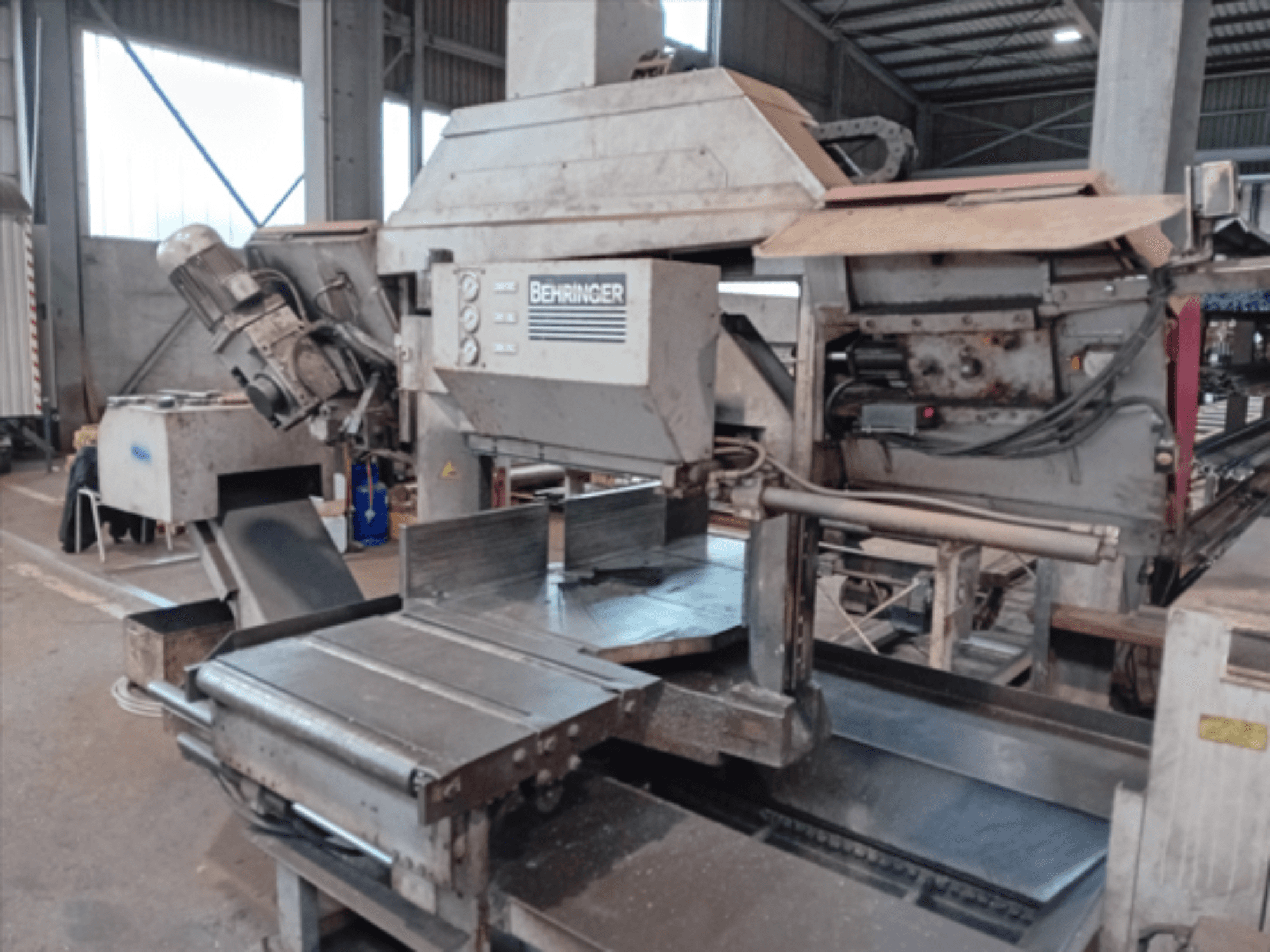 Behringer tračna pila, pogled sprijeda, ima veliku oštricu, motor i podesivi stol, idealna za rezanje metala u radionici.