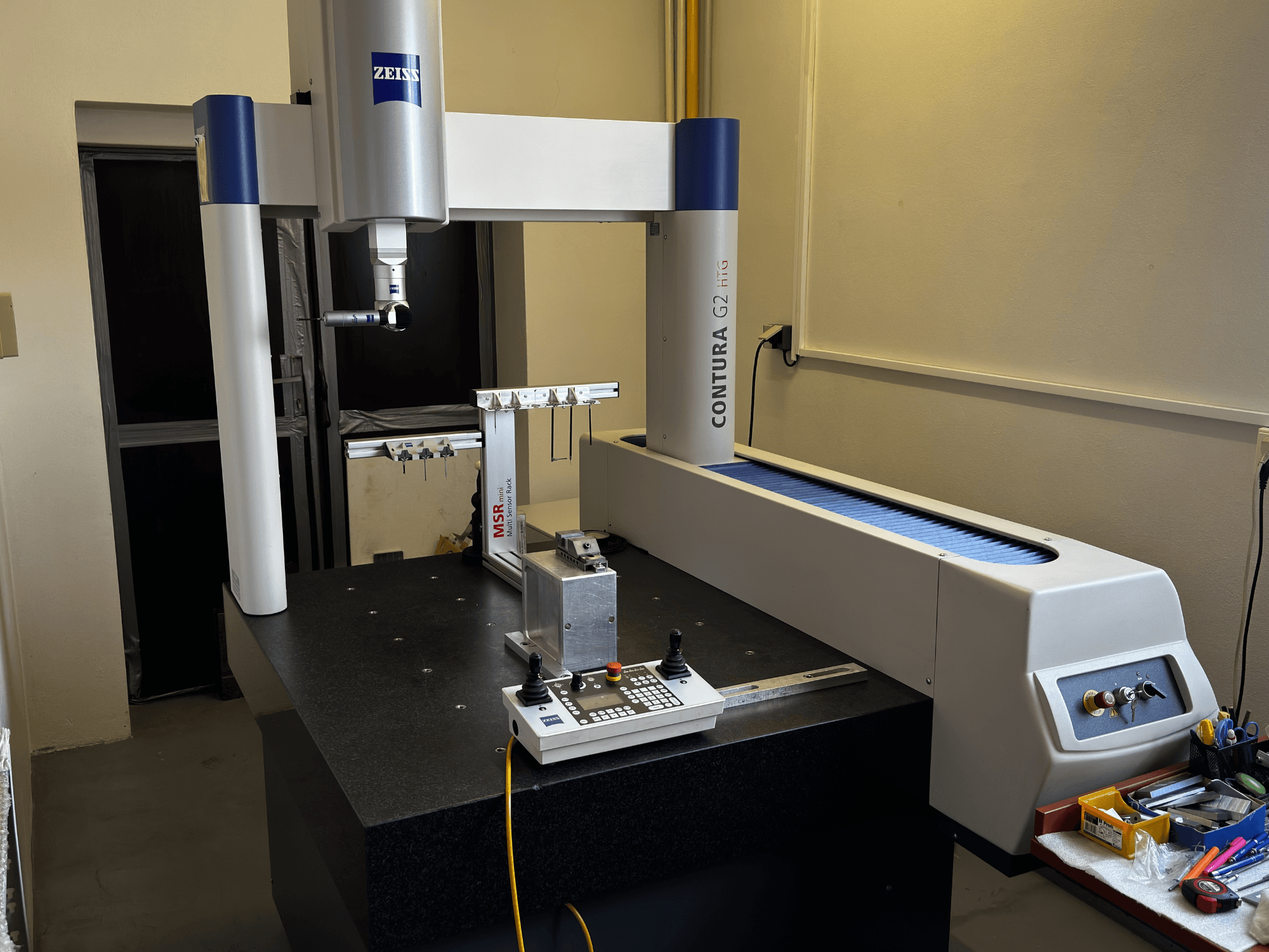 ZEISS Contura G2 CMM u laboratorijskom okruženju, prednji pogled koji prikazuje mjernu ruku, upravljačku ploču i susjedni radni prostor.