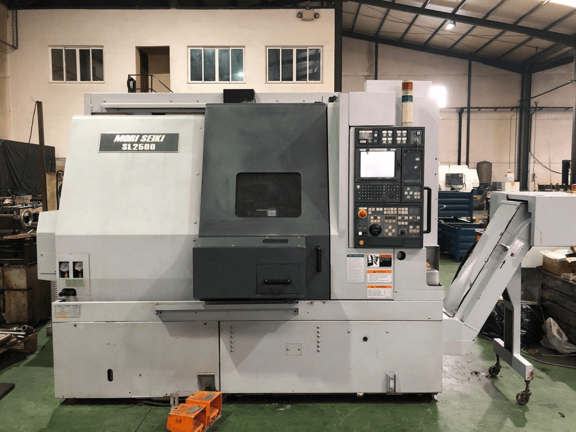 DMG Mori Seiki SL 2500 Y tokarsko-glodački centar, bočni pogled s vidljivom upravljačkom pločom i transporterom strugotine.