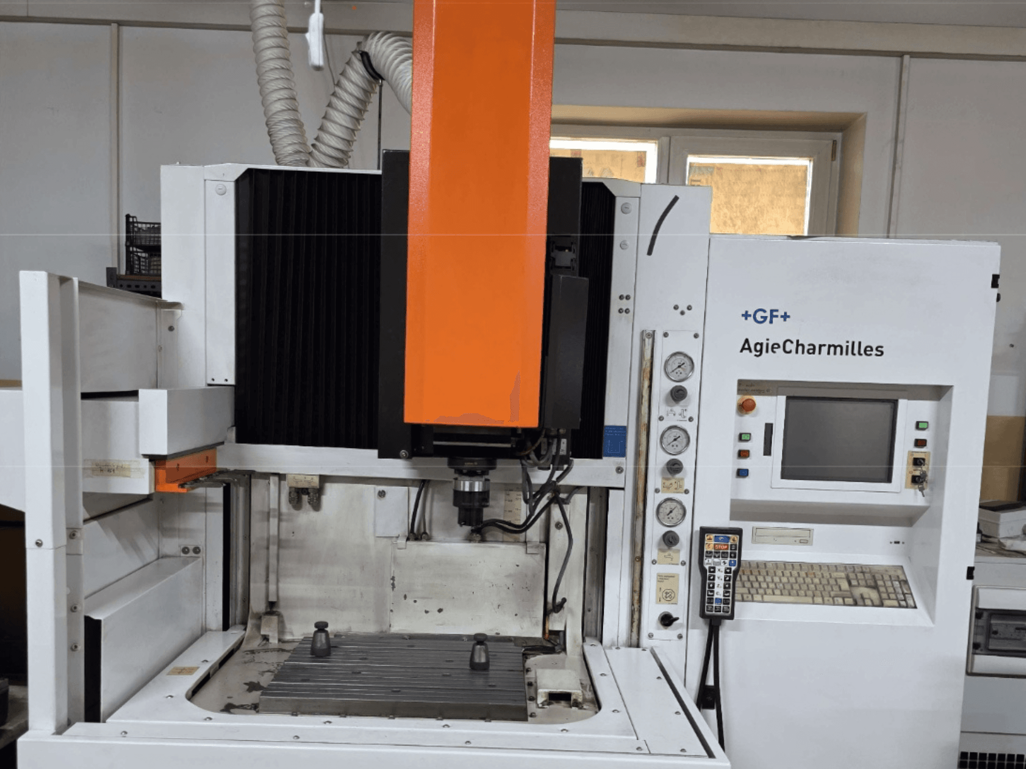 AgieCharmilles obradni centar u prednjem pogledu s velikim narančastim vretenom, upravljačkom pločom i vidljivim radnim stolom.