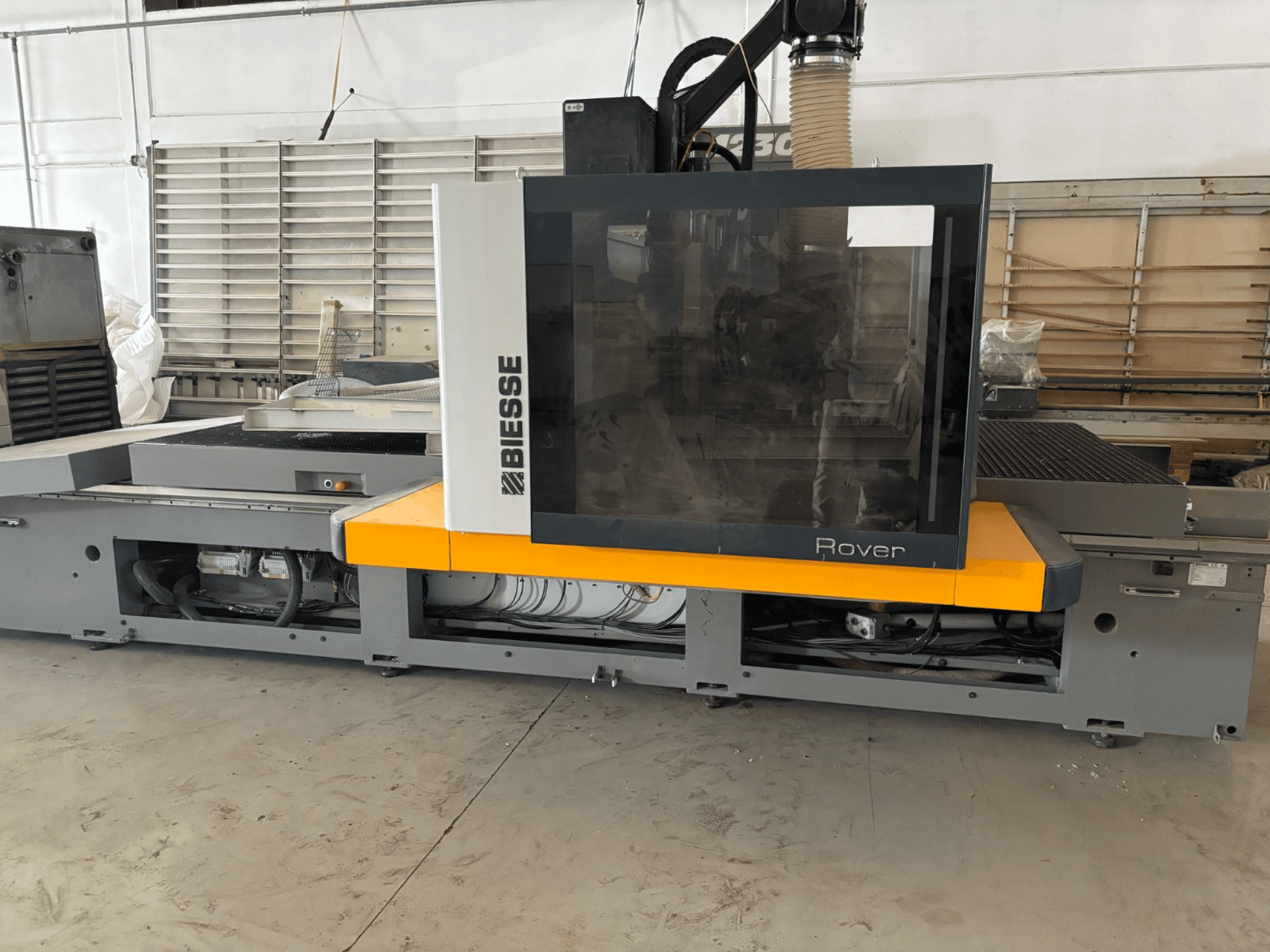 Biesse Rover CNC obradni centar, prednji pogled, ima veliku upravljačku ploču, žute detalje i izložene mehaničke komponente.