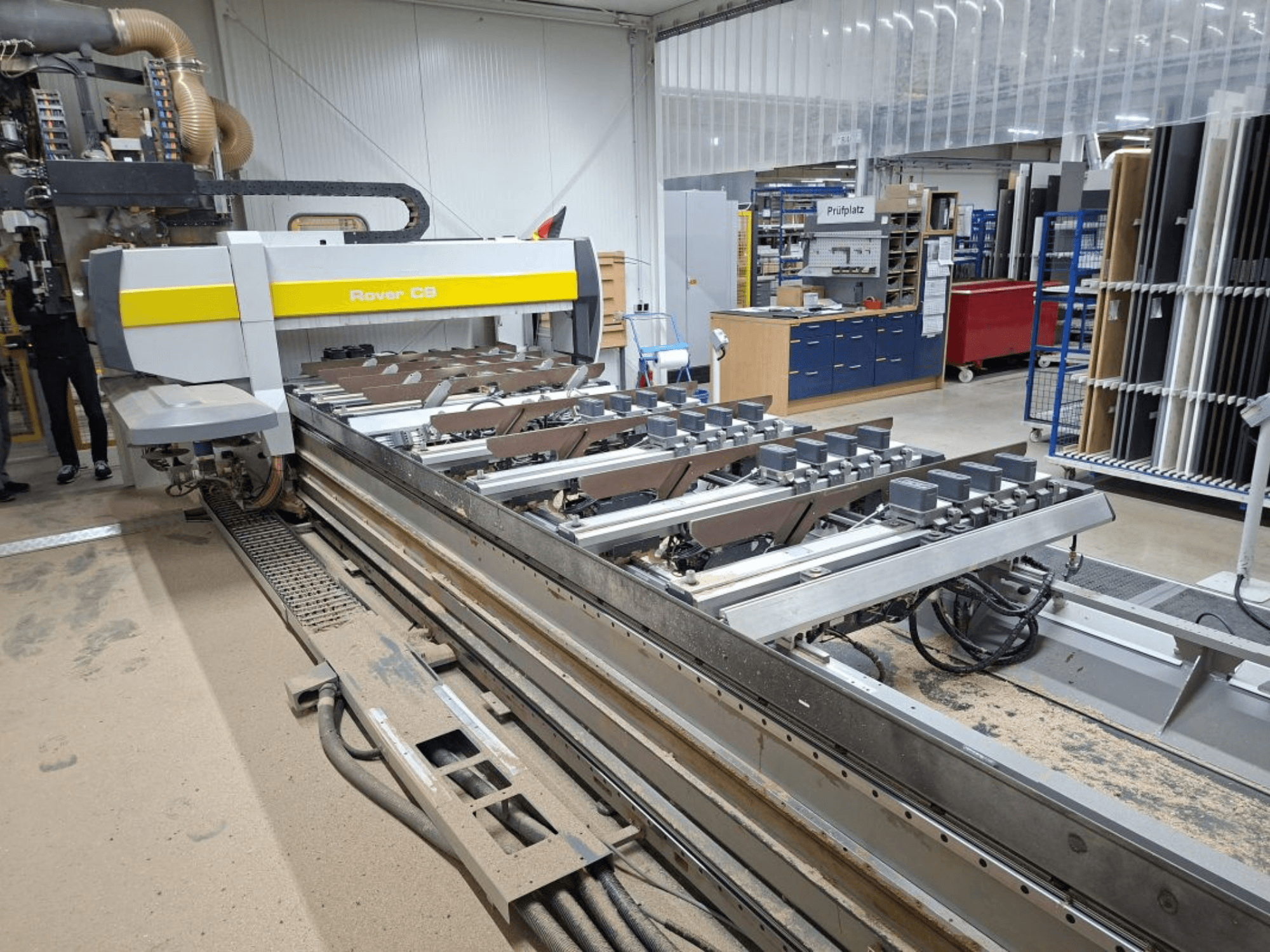 CNC stroj Rover C9 u radionici, prednji pogled, s vidljivom rezačkom platformom i više stezaljki, okružen opremom.