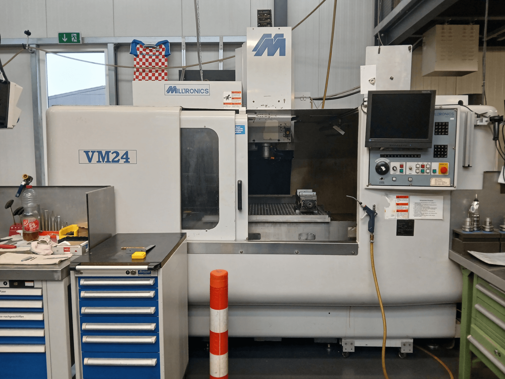 CNC glodalica Milltronics VM24 prikazana s prednje strane, s upravljačkom pločom, prostorom za pohranu alata i postavkama radnog prostora.