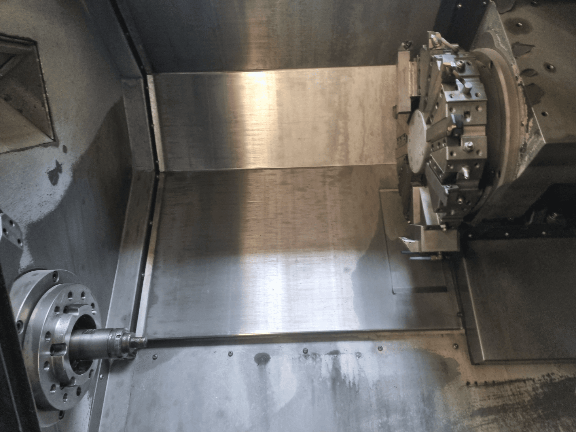 Unutarnji pogled na CNC tokarilicu s rotirajućim vretenom i metalnom radnom površinom, koji prikazuje industrijsko precizno inženjerstvo.