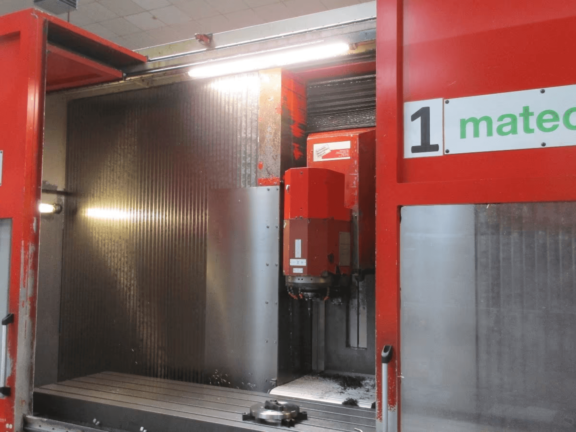 Prednji pogled na vertikalni obradni centar Matec 30 HV CNC s vidljivim alatom za rezanje, metalnom površinom i detaljima unutrašnjosti stroja.