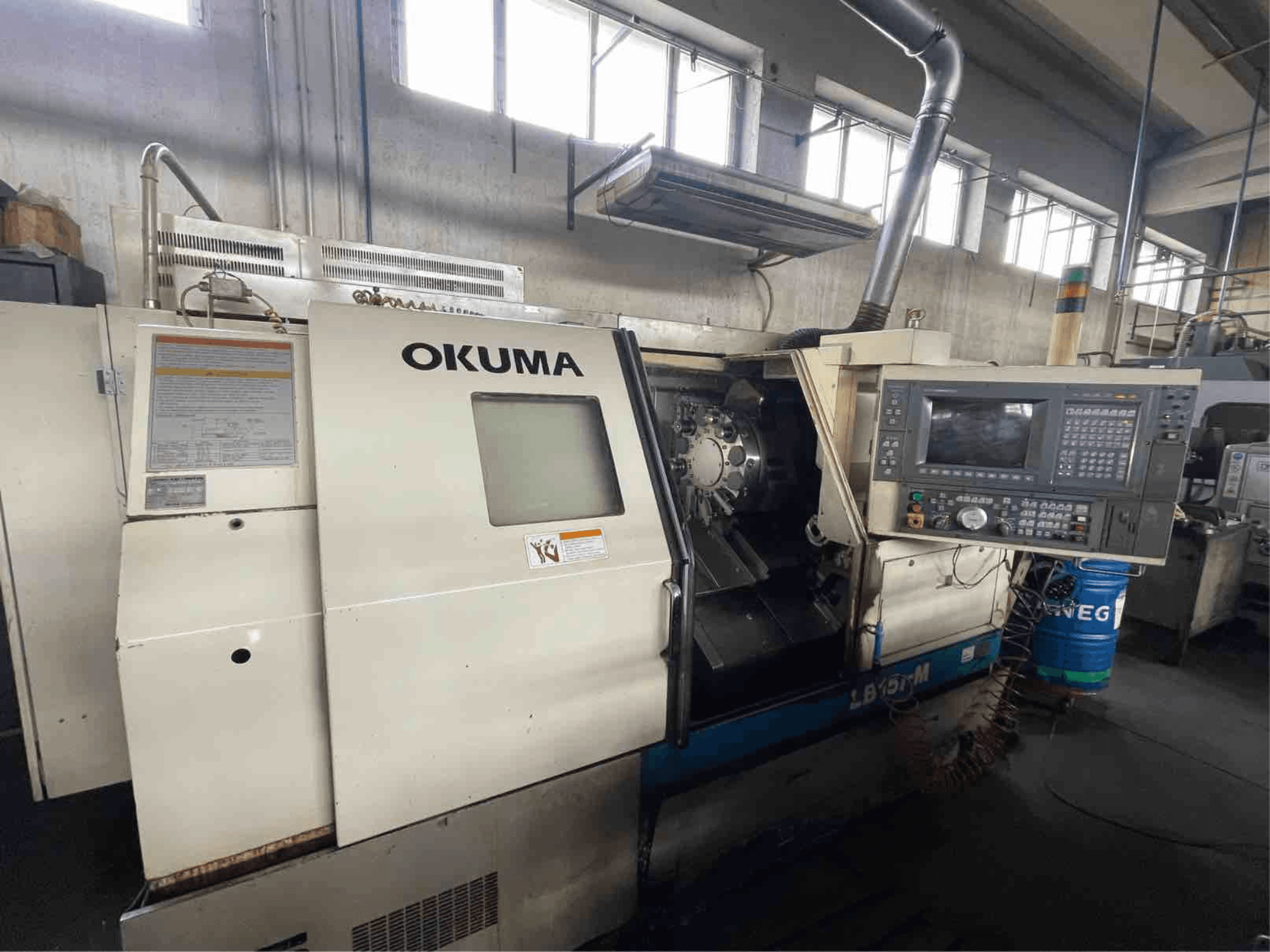 Okuma LB15i-M horizontalni tokarski stroj, pogled sprijeda; sadrži upravljačku ploču i područje alata za rezanje s detaljnim indikatorima.