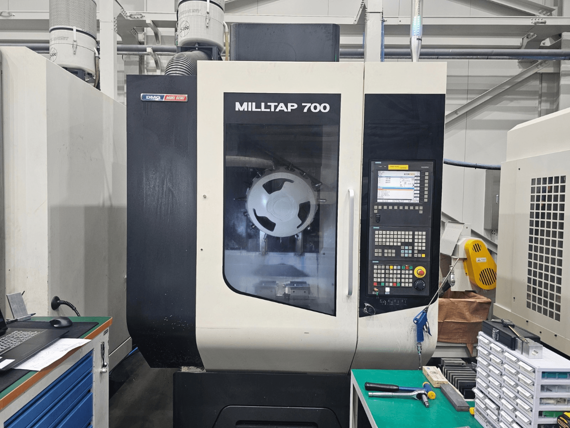 Vertikalni obradni centar DMG MORI MILLTAP 700, prednji pogled, prikaz upravljačke ploče, vretena i detalja radnog prostora.