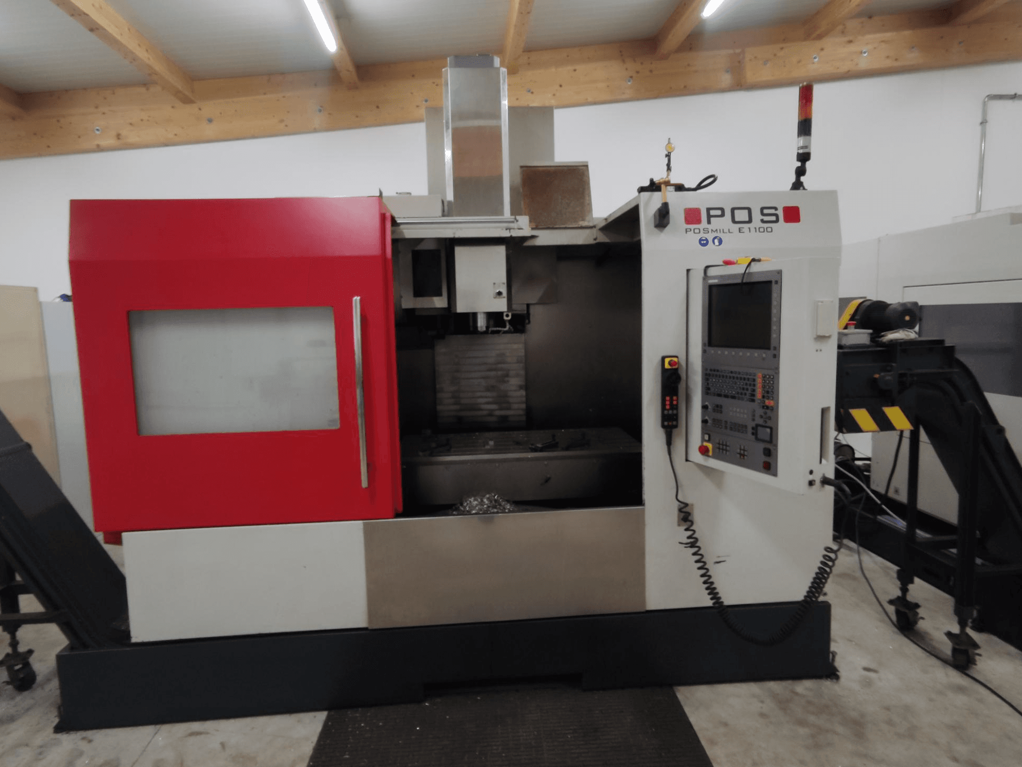 POS POSMILL E1100 CNC glodalica u prednjem pogledu s crvenim kućištem, upravljačkom pločom i sigurnosnim svjetlom na vrhu.